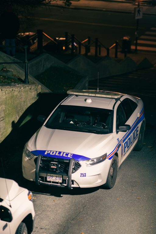 Modern automobile with Police inscriptions and tinted glass parked on asphalt roadway in city at dusk