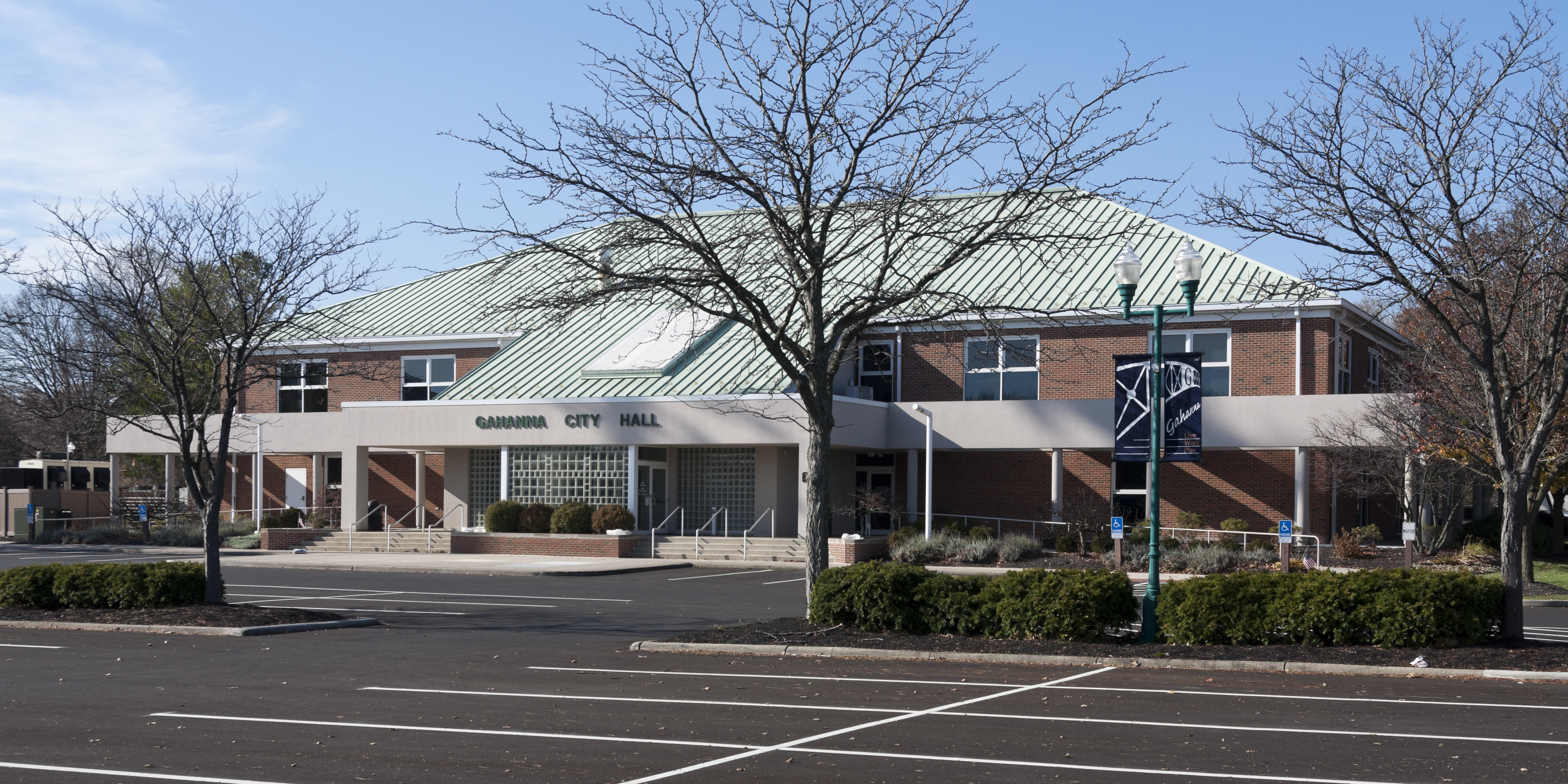 Exterior of a low-rise brick government building under a clear sky.