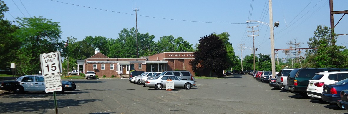 Single-story brick police station building with a parking lot in front.