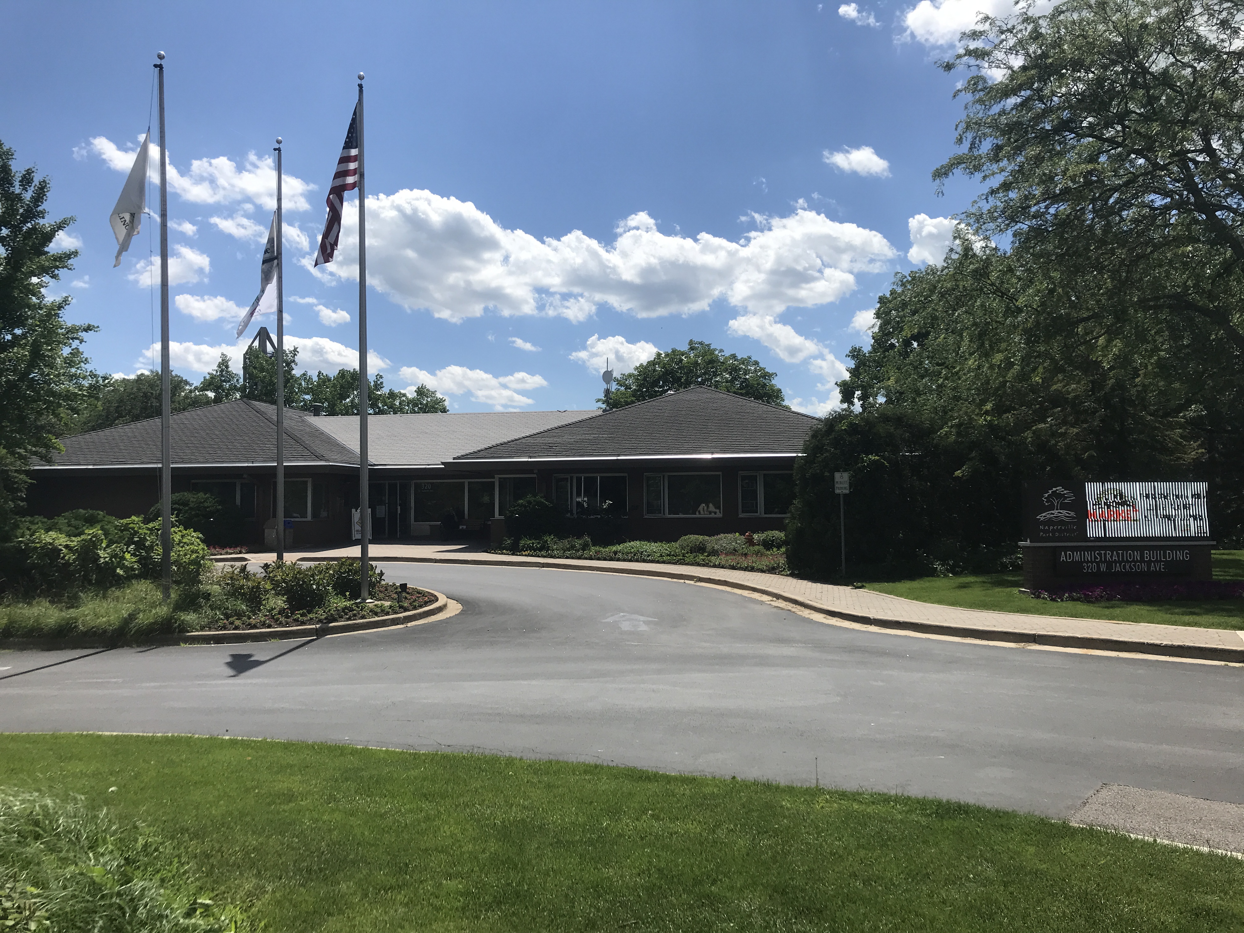 Exterior of the Naperville Park District Administrative Building, a brick civic structure with landscaping.