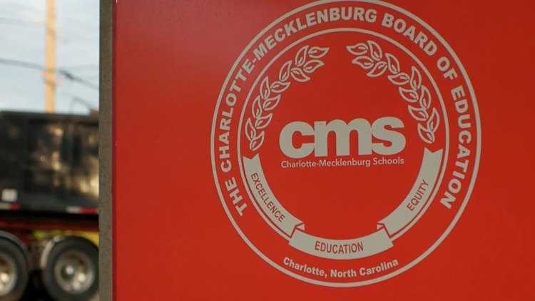 Red sign displaying the Charlotte-Mecklenburg Board of Education official seal.