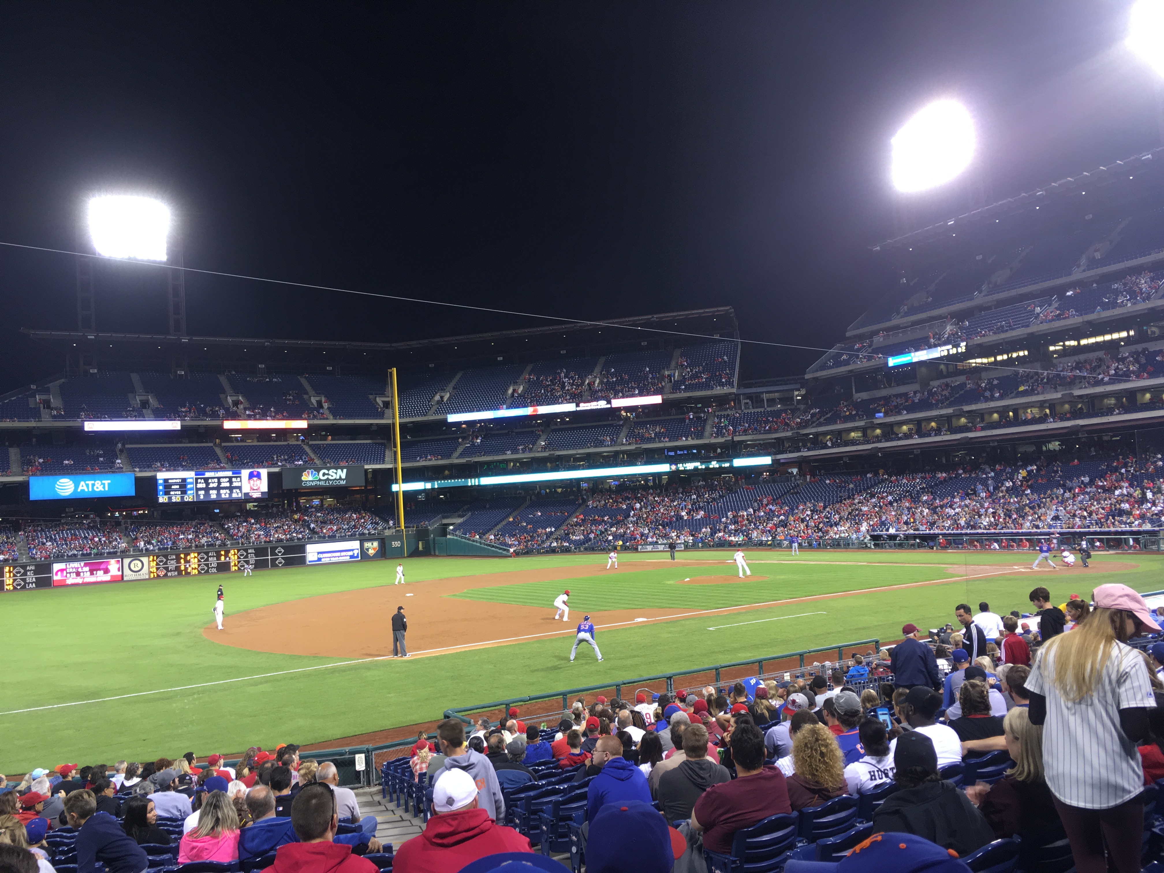 Nighttime baseball game at a packed stadium under bright lights.