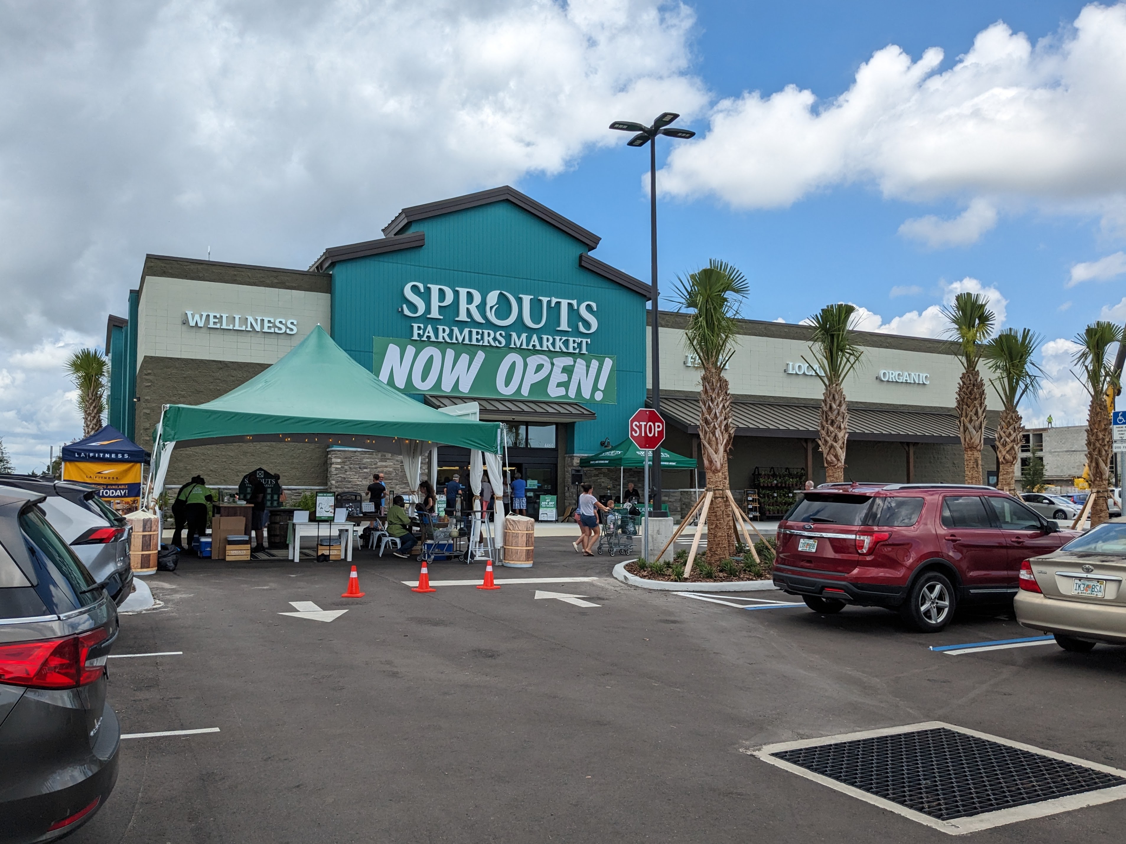Sprouts Farmers Market storefront with teal exterior and a NOW OPEN banner.