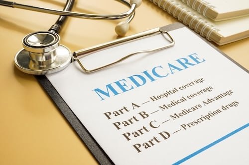 Clipboard with a Medicare coverage document and a stethoscope resting on top.