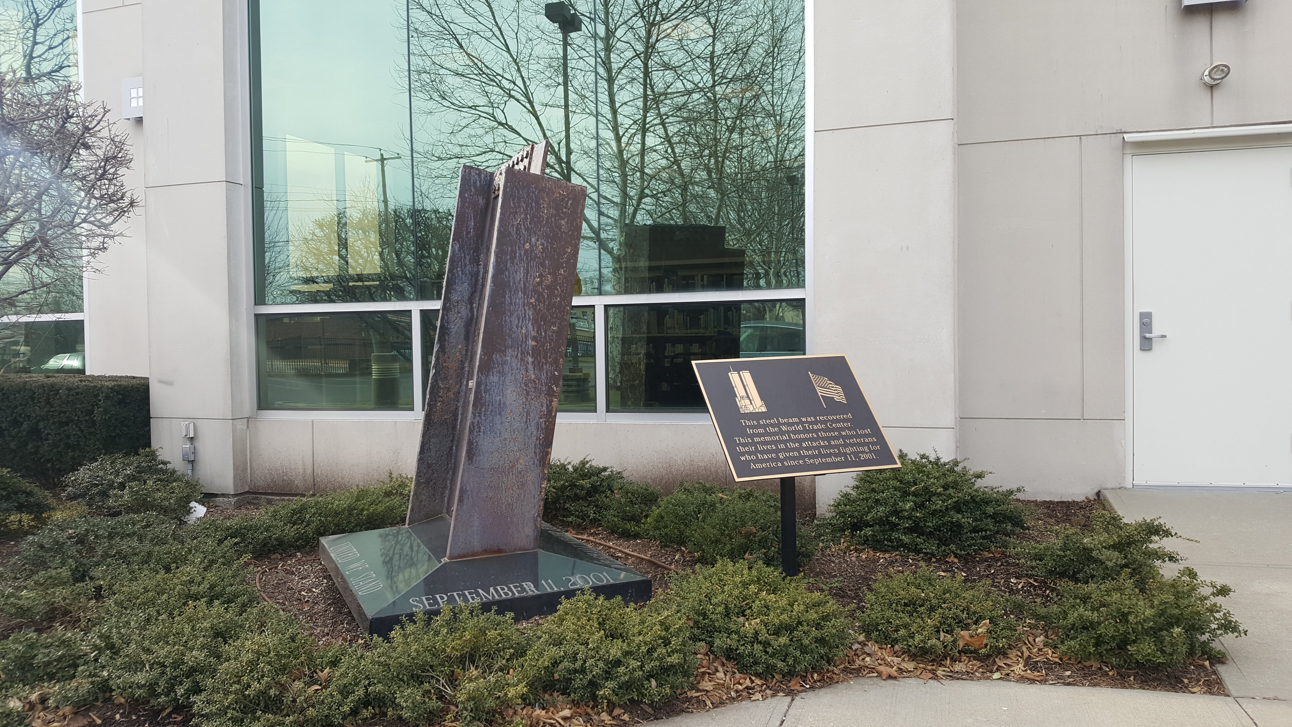 Steel beam from the World Trade Center mounted on a granite base at an outdoor 9/11 memorial.