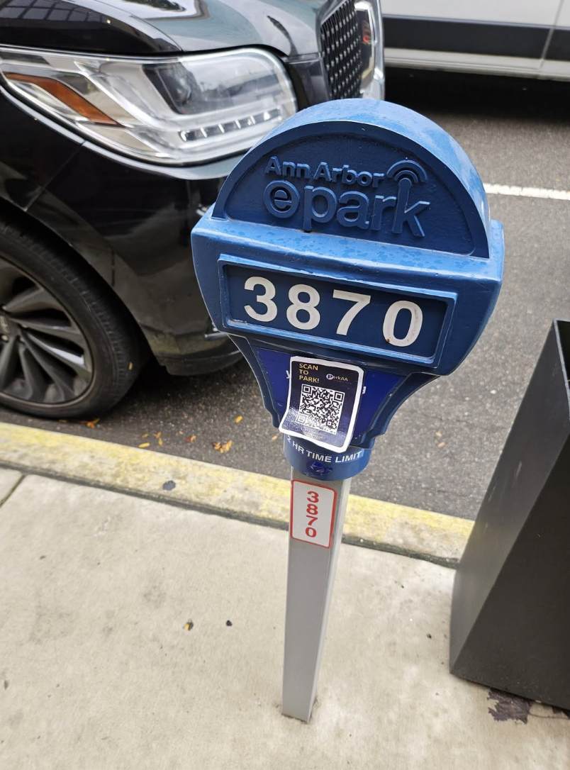 Ann Arbor ePark meter with a fraudulent “Scan to Park” QR code sticker attached below the meter number.