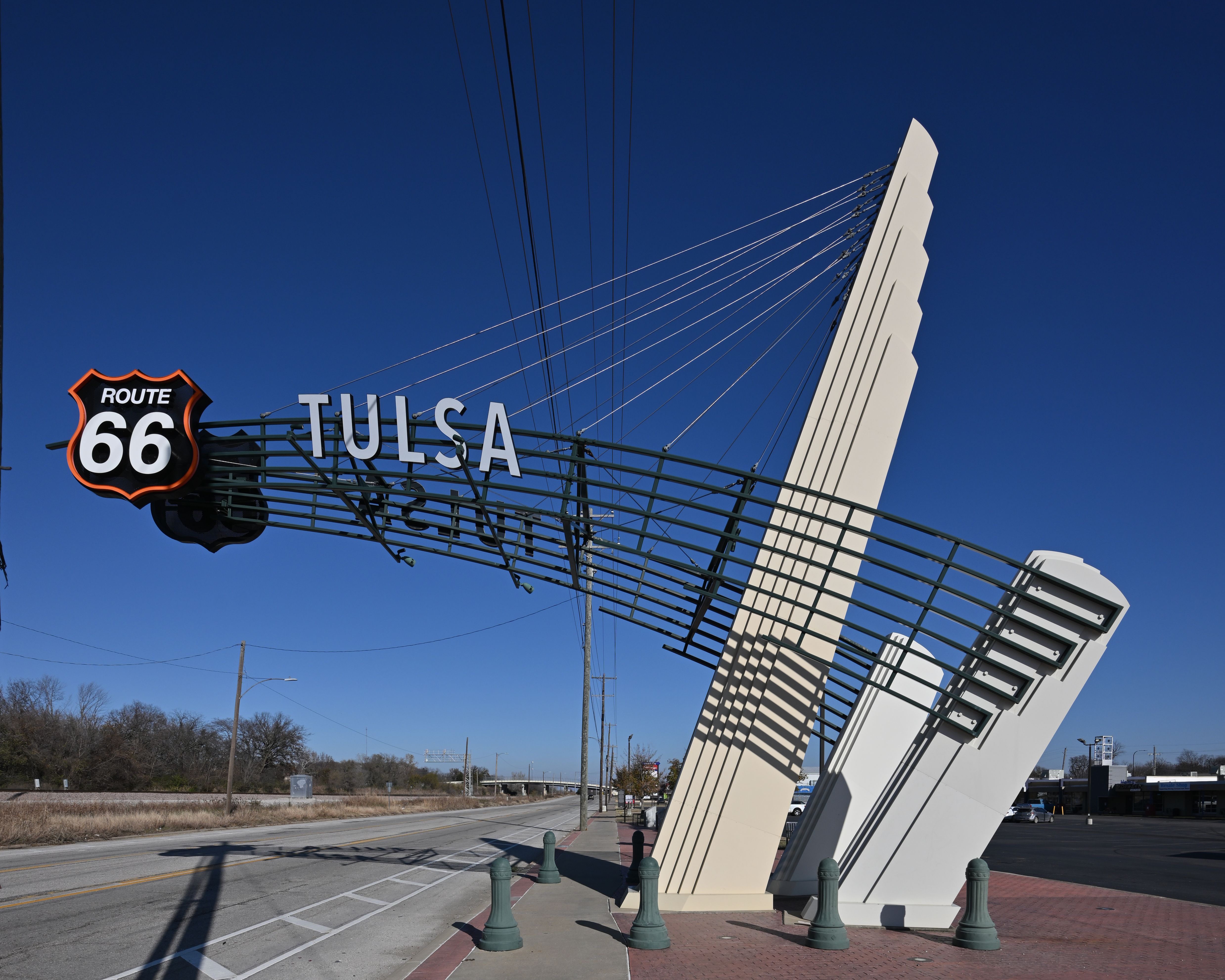 Large illuminated Tulsa sign with Route 66 shield on an angular steel structure.