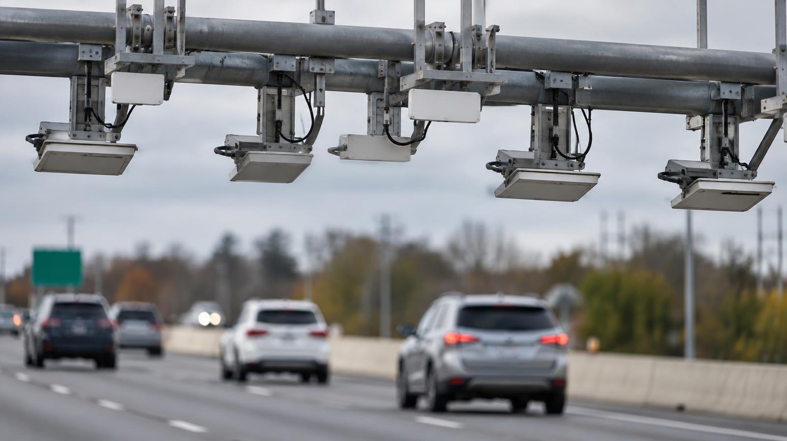 Overhead toll gantry with electronic sensors over a multi-lane highway.