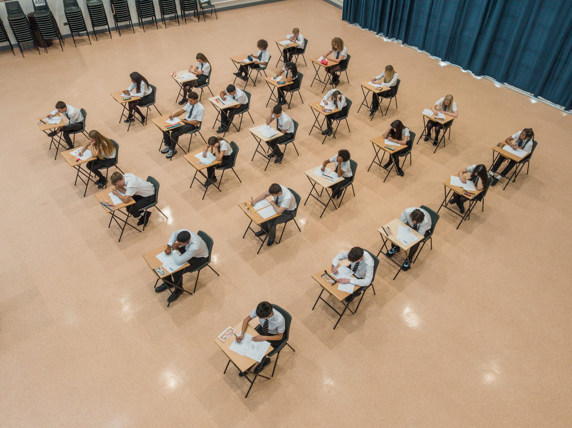 Twenty five teenage students sitting an exam in a high school building shot from an aerial perspective, Newcastle upon Tyne, England, United Kingdom