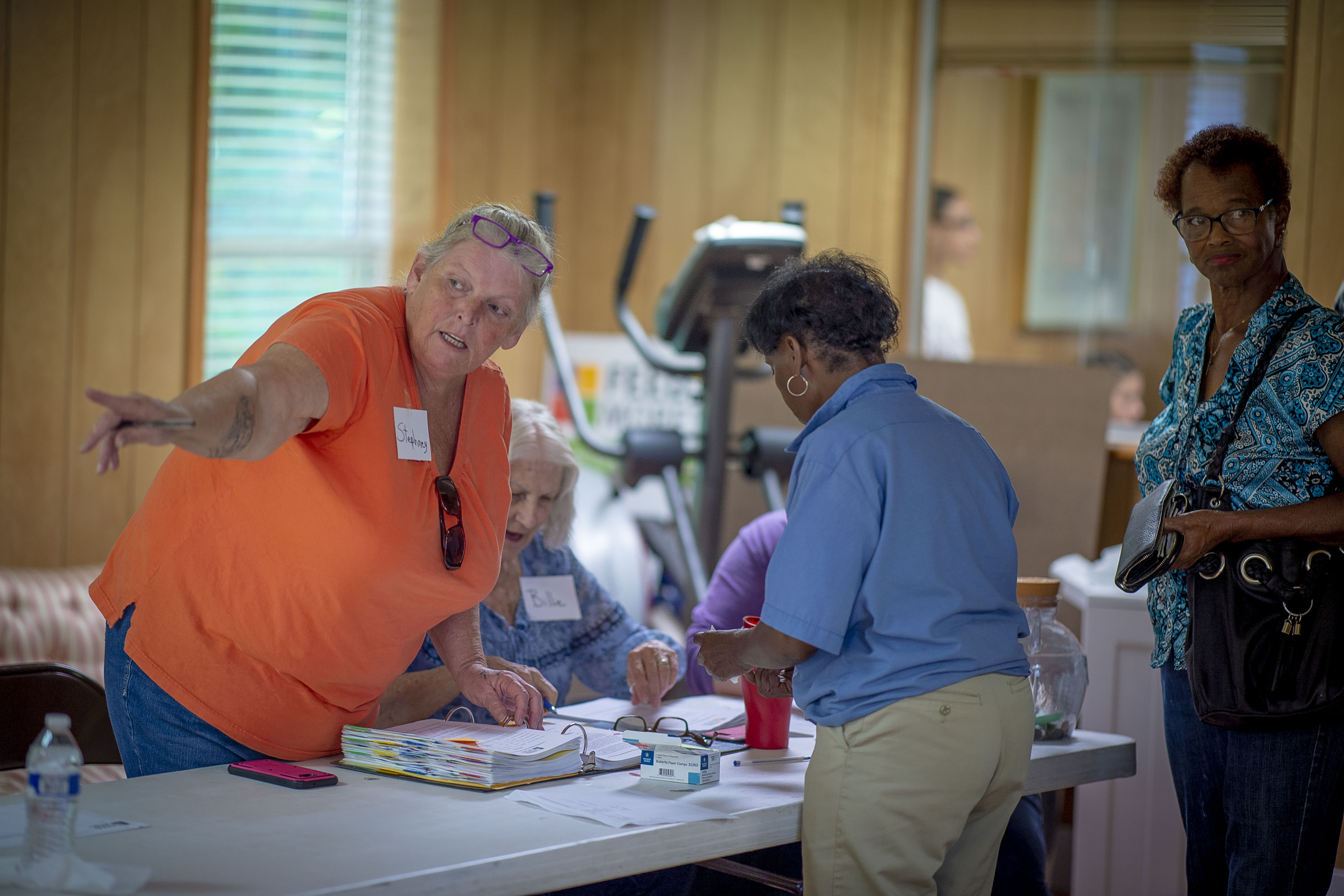 Volunteers and a client gathered around a registration table inside a community food pantry.