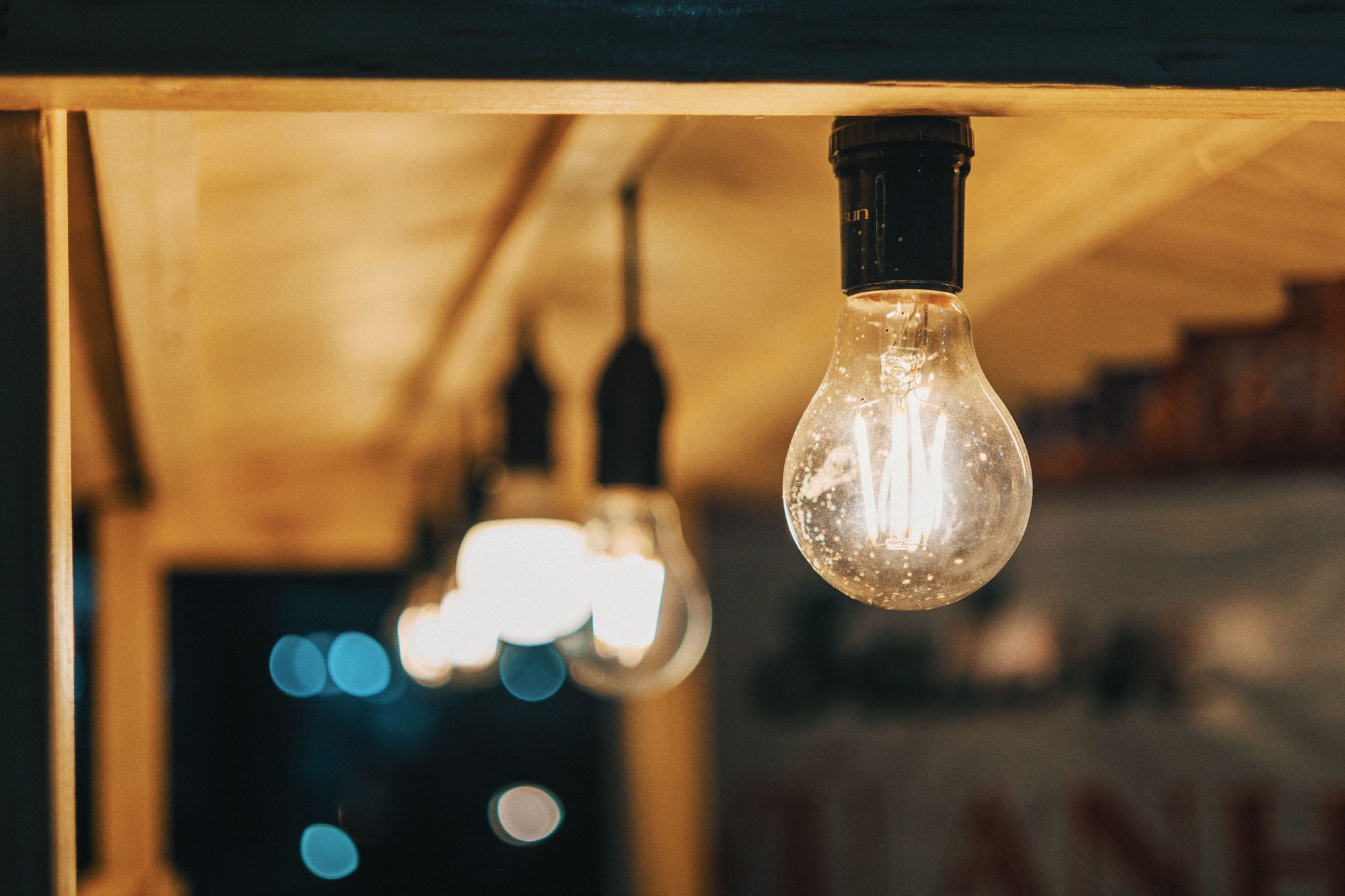 Warmly lit hanging light bulbs captured in an indoor setting, creating a cozy ambiance.