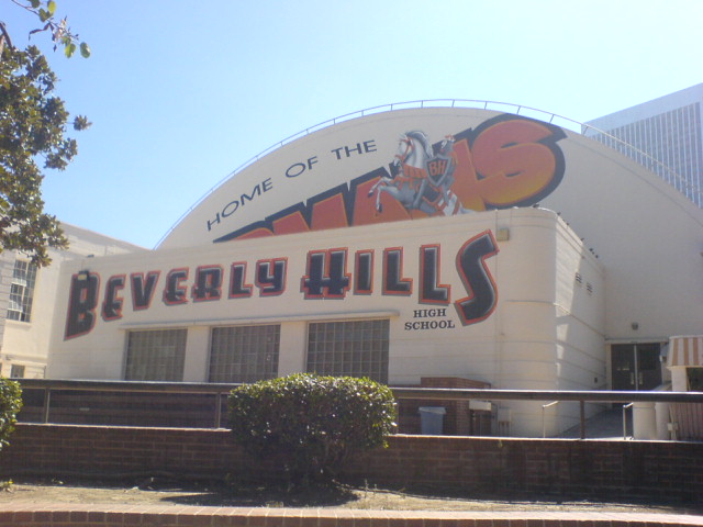 Exterior of Beverly Hills High School's curved gymnasium building with a painted mural.