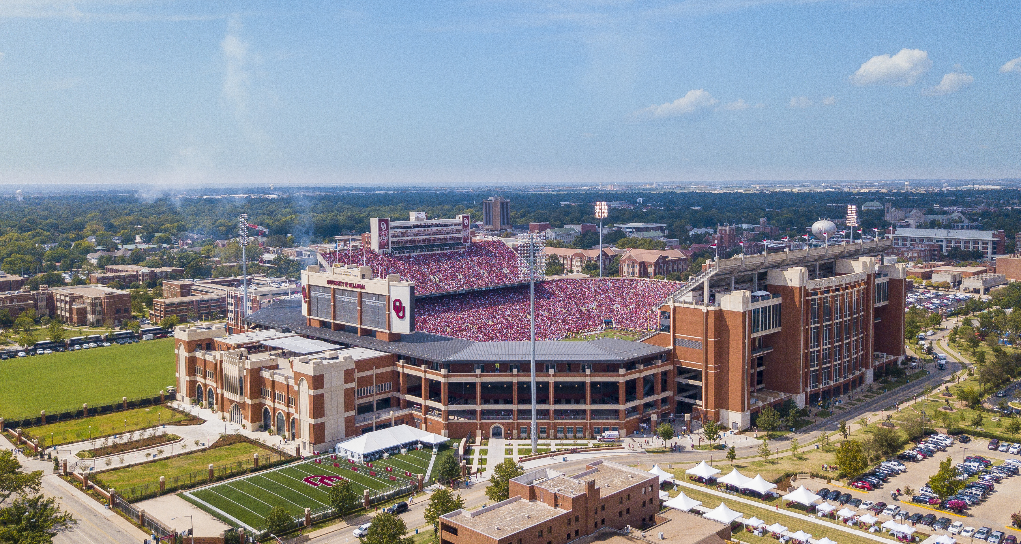Aerial view of a packed college football stadium surrounded by campus buildings.