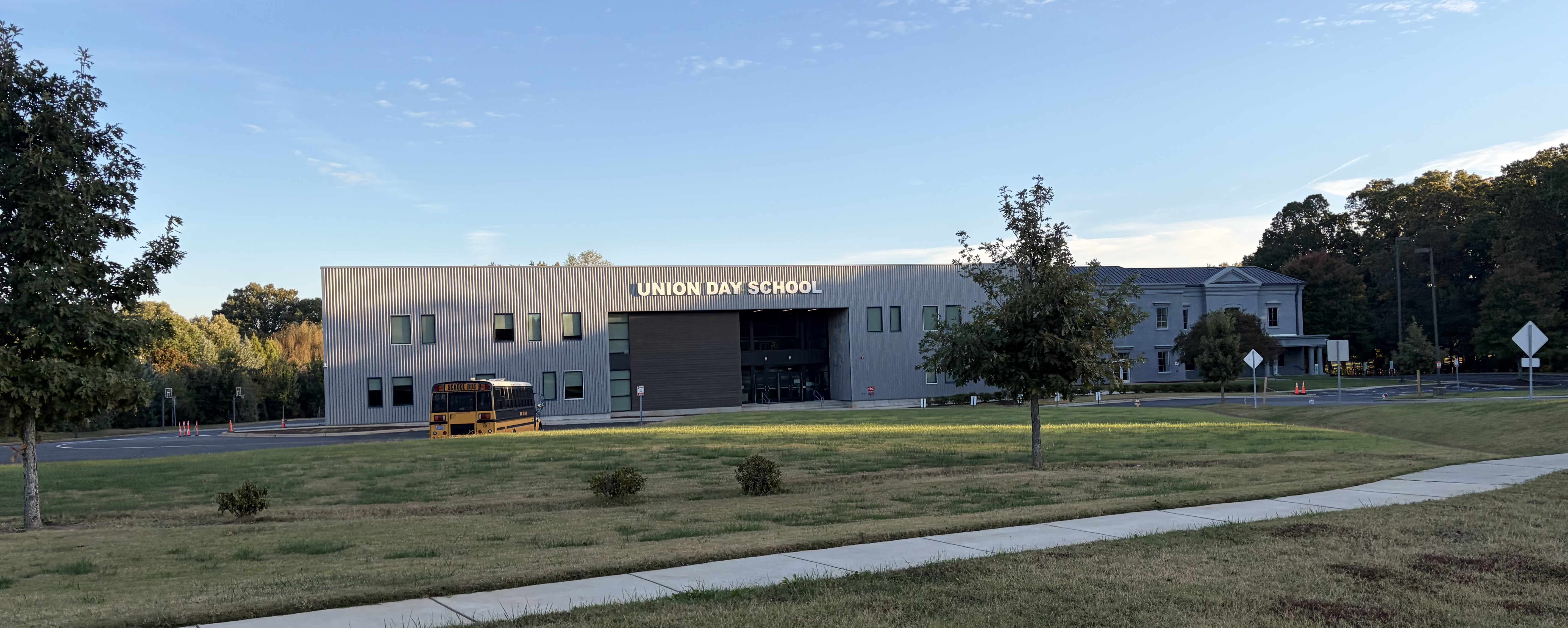 Exterior of a school building with a yellow bus parked in front.