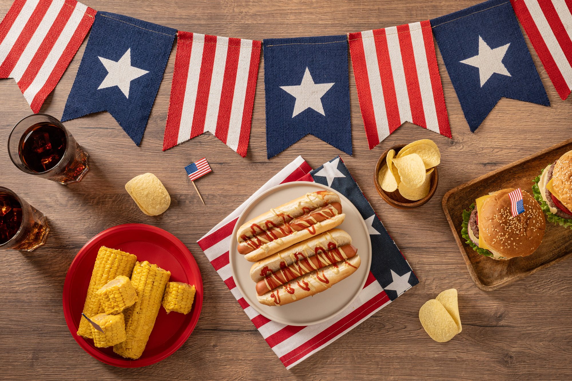 American Independence Day barbecue table with burgers hot dogs and patriotic party food