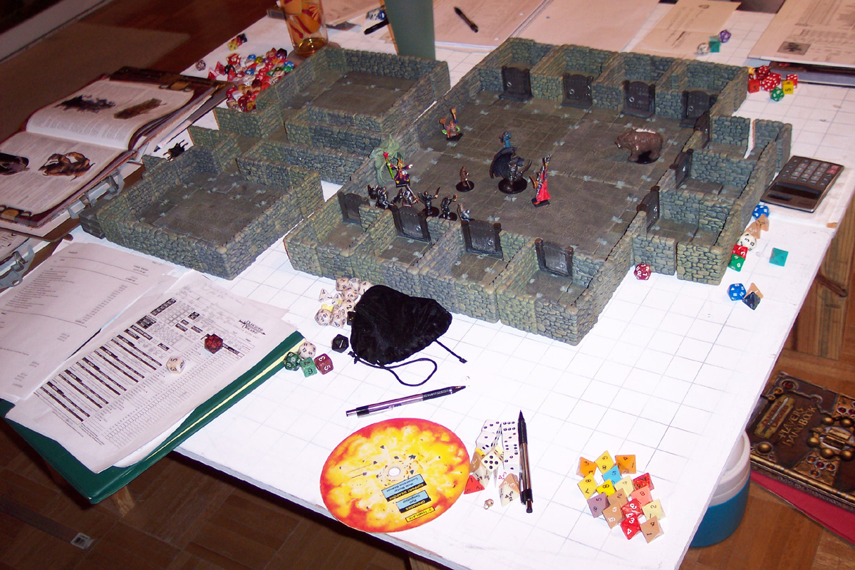Tabletop D&D game setup with miniature figures in a 3D dungeon, dice, and character sheets.