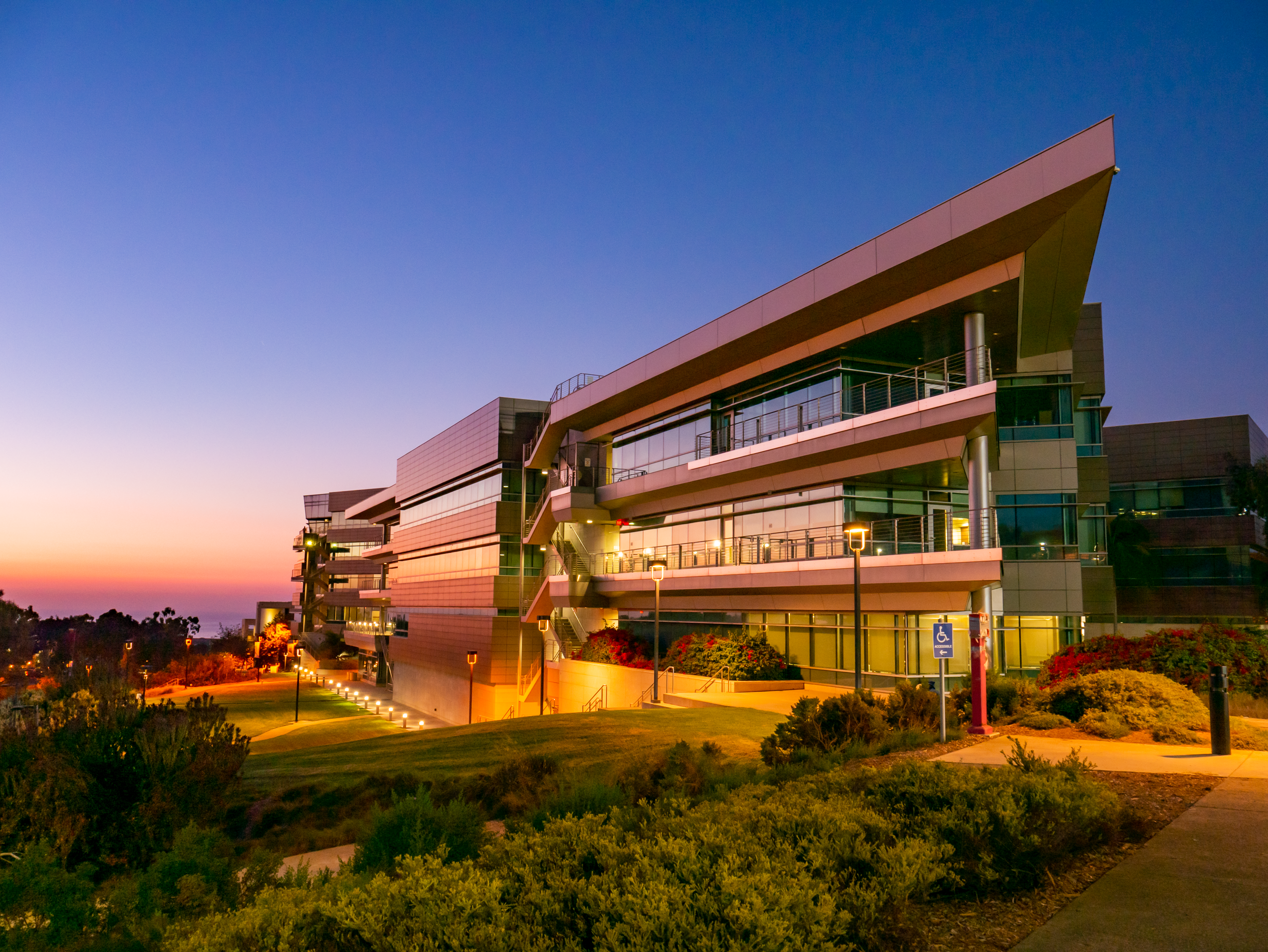 The Rady School of Management building at dusk, lit by exterior lights.