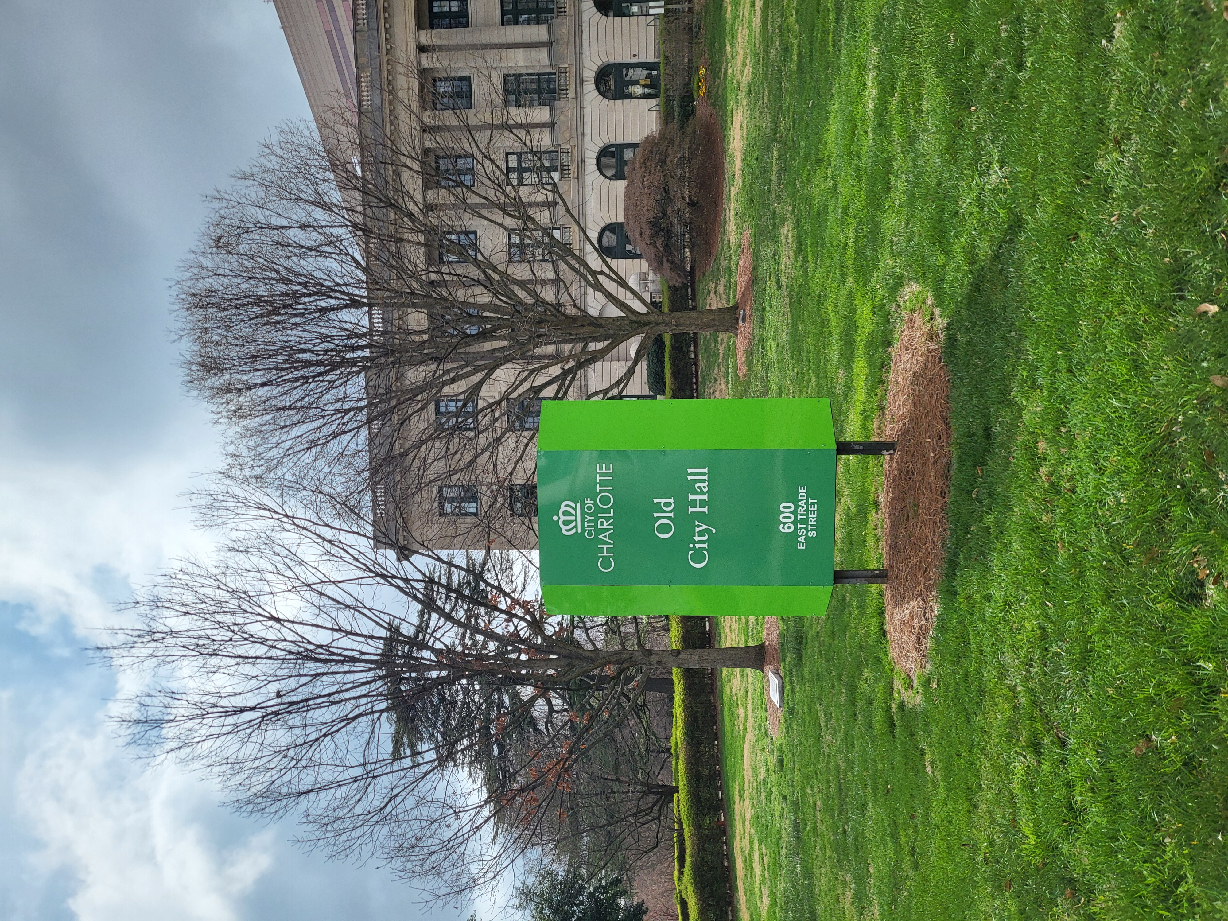 Green City of Charlotte sign reading Old City Hall in front of a stone government building.