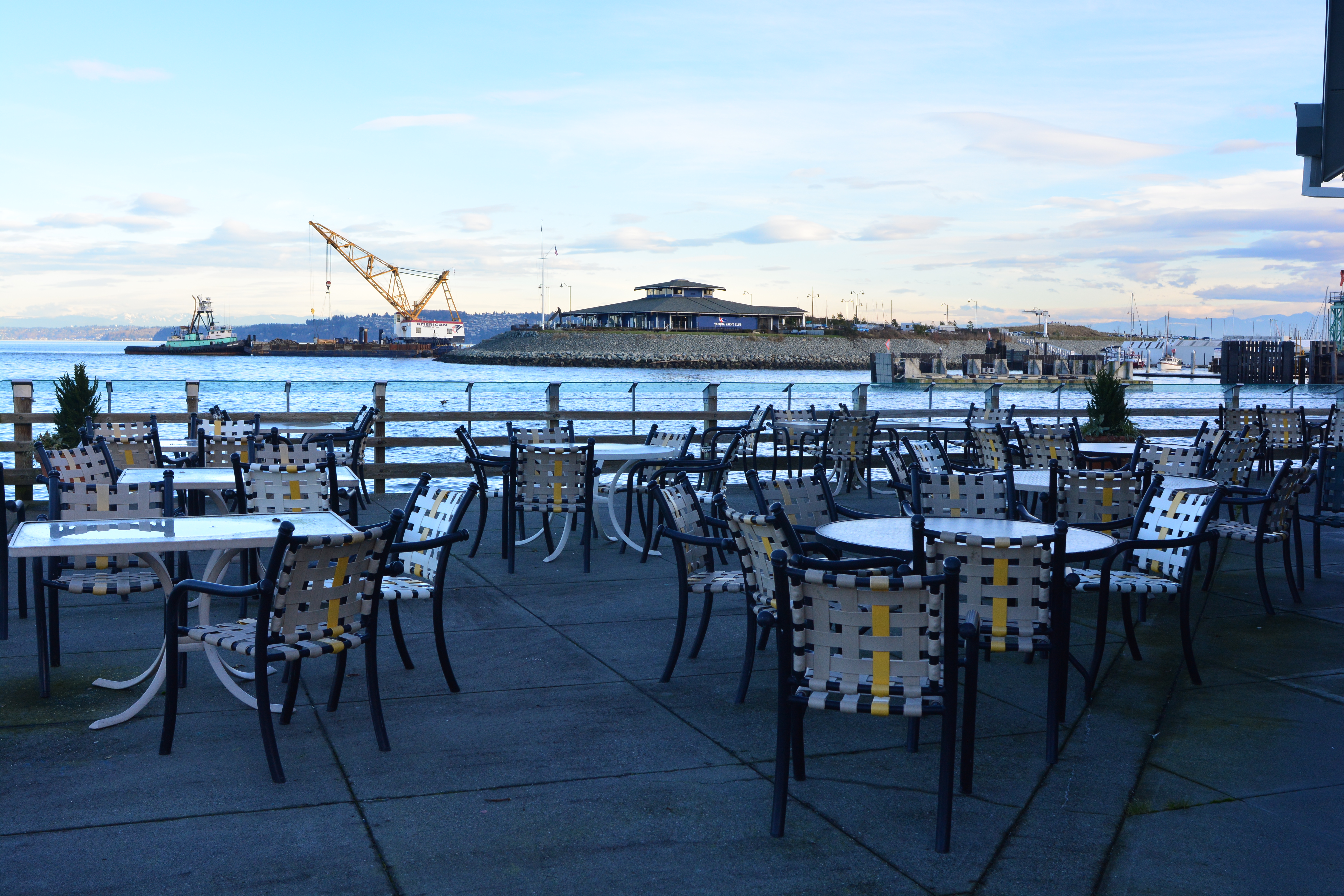 Waterfront patio at Point Defiance Marina overlooking the harbor with docks and marina buildings in the background.
