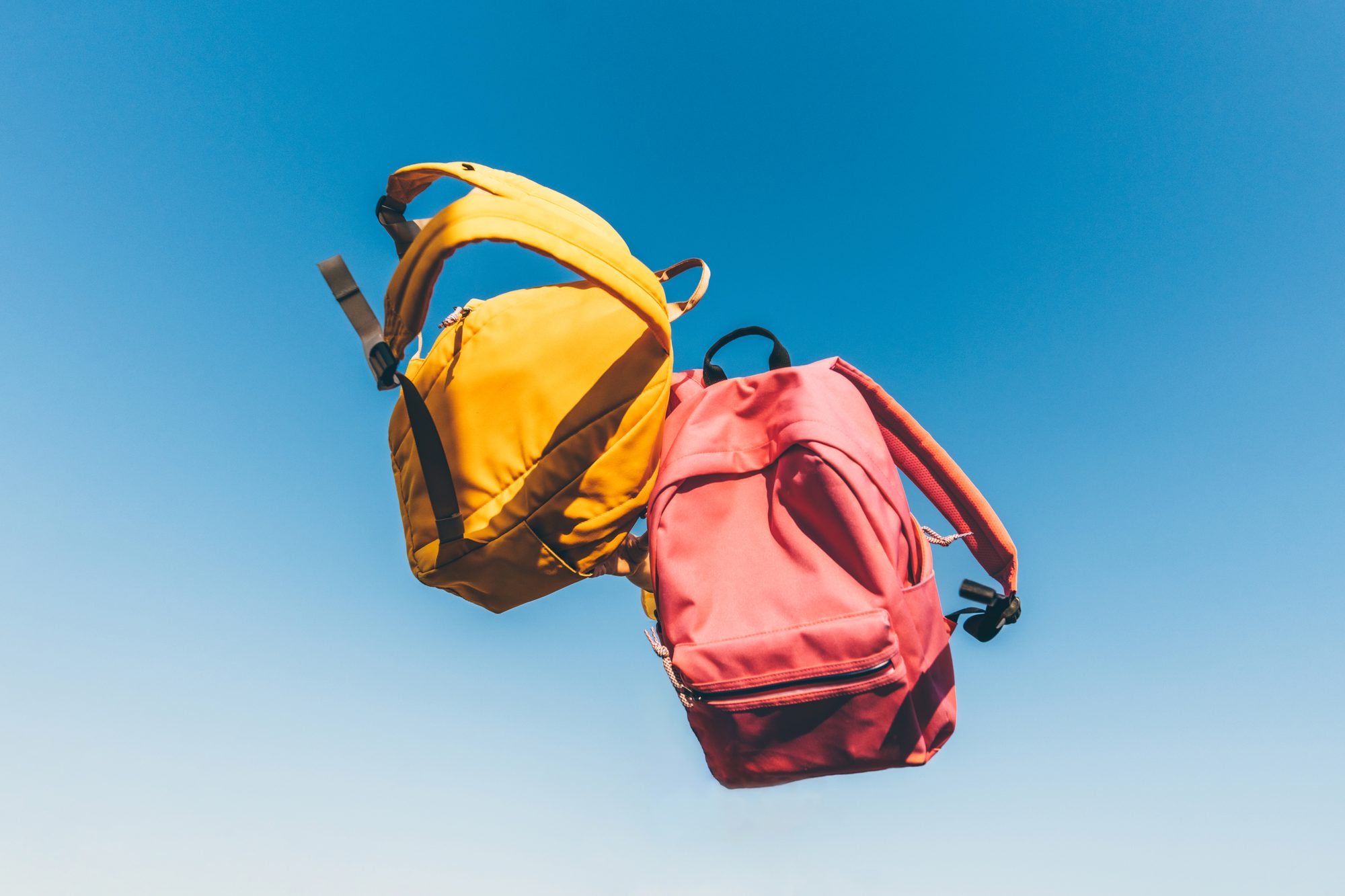 Multicolored backpacks on sky background. Back to school concept.