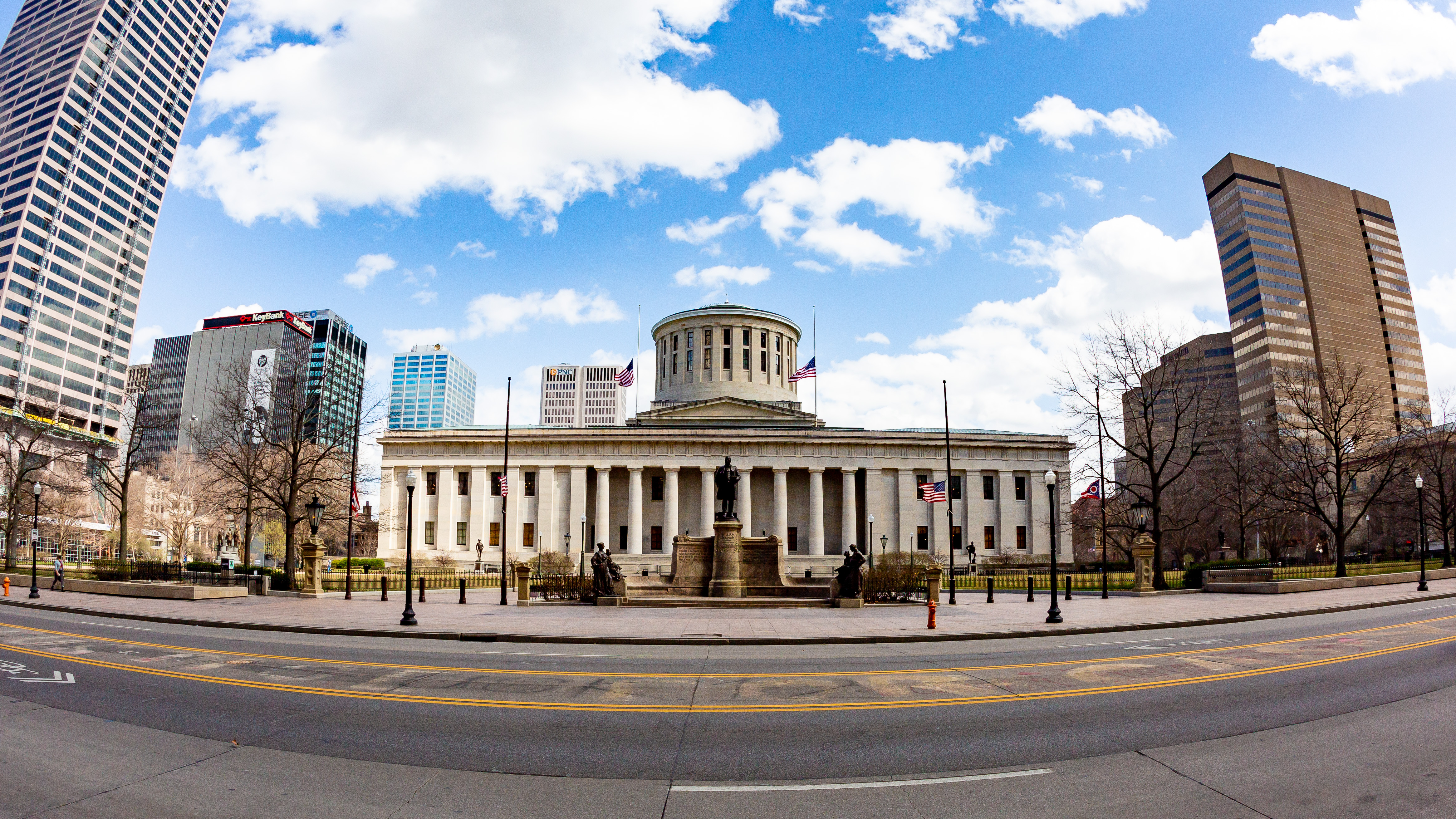 Ohio Statehouse with Greek Revival columns and dome seen from a city street.