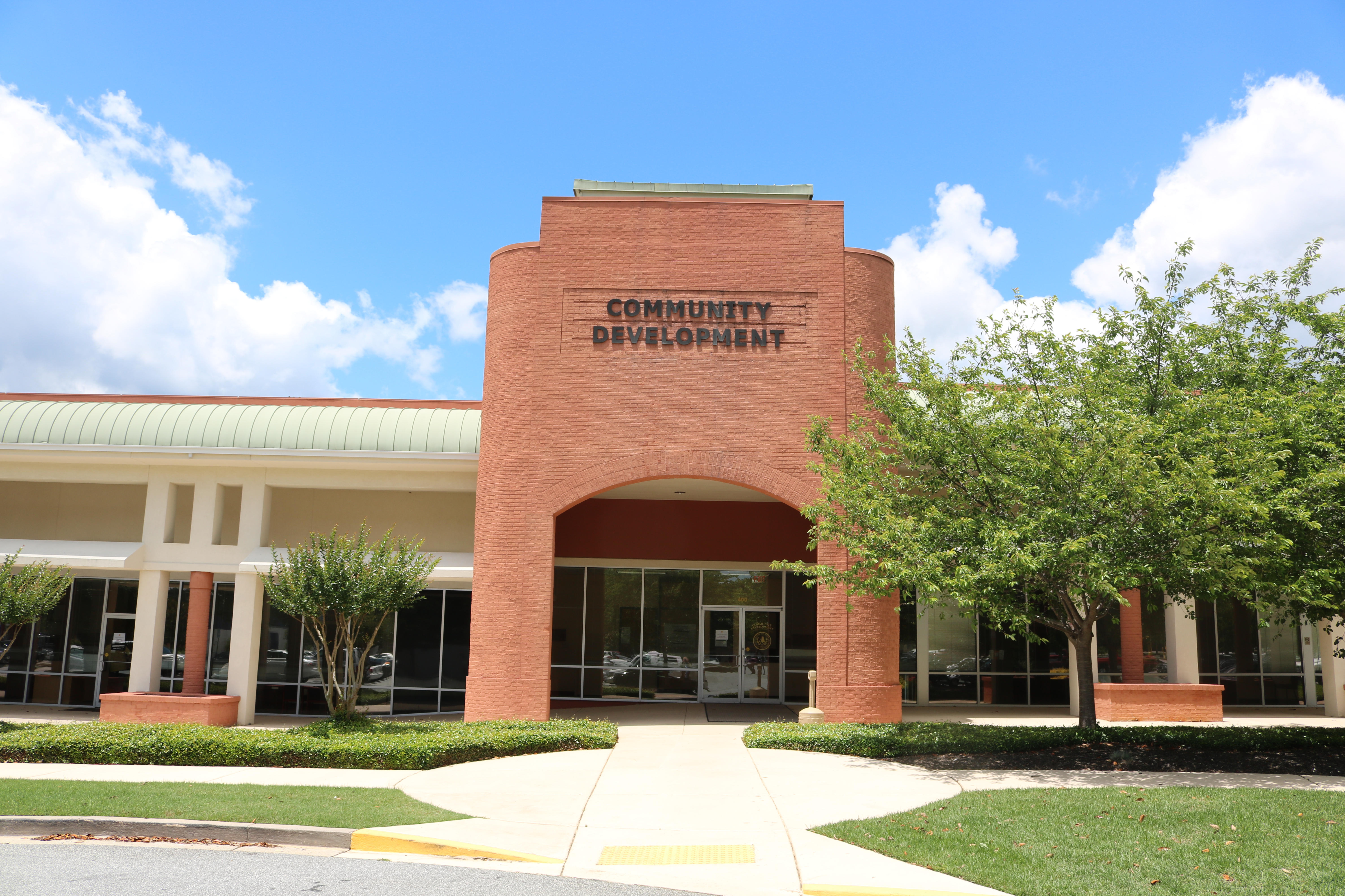 Brick government building labeled Community Development with an arched entrance and green roof.
