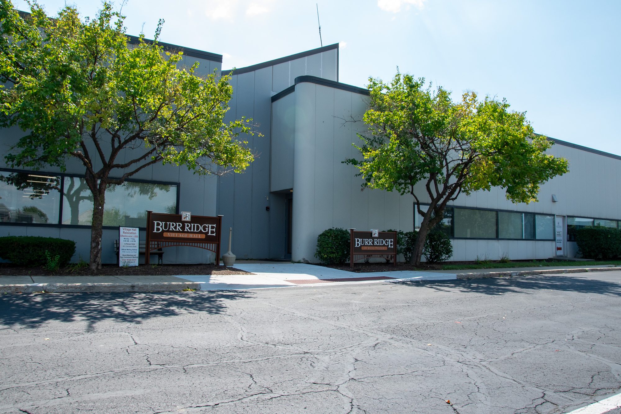 Exterior facade of Burr Ridge Village Hall with freestanding identification signs.