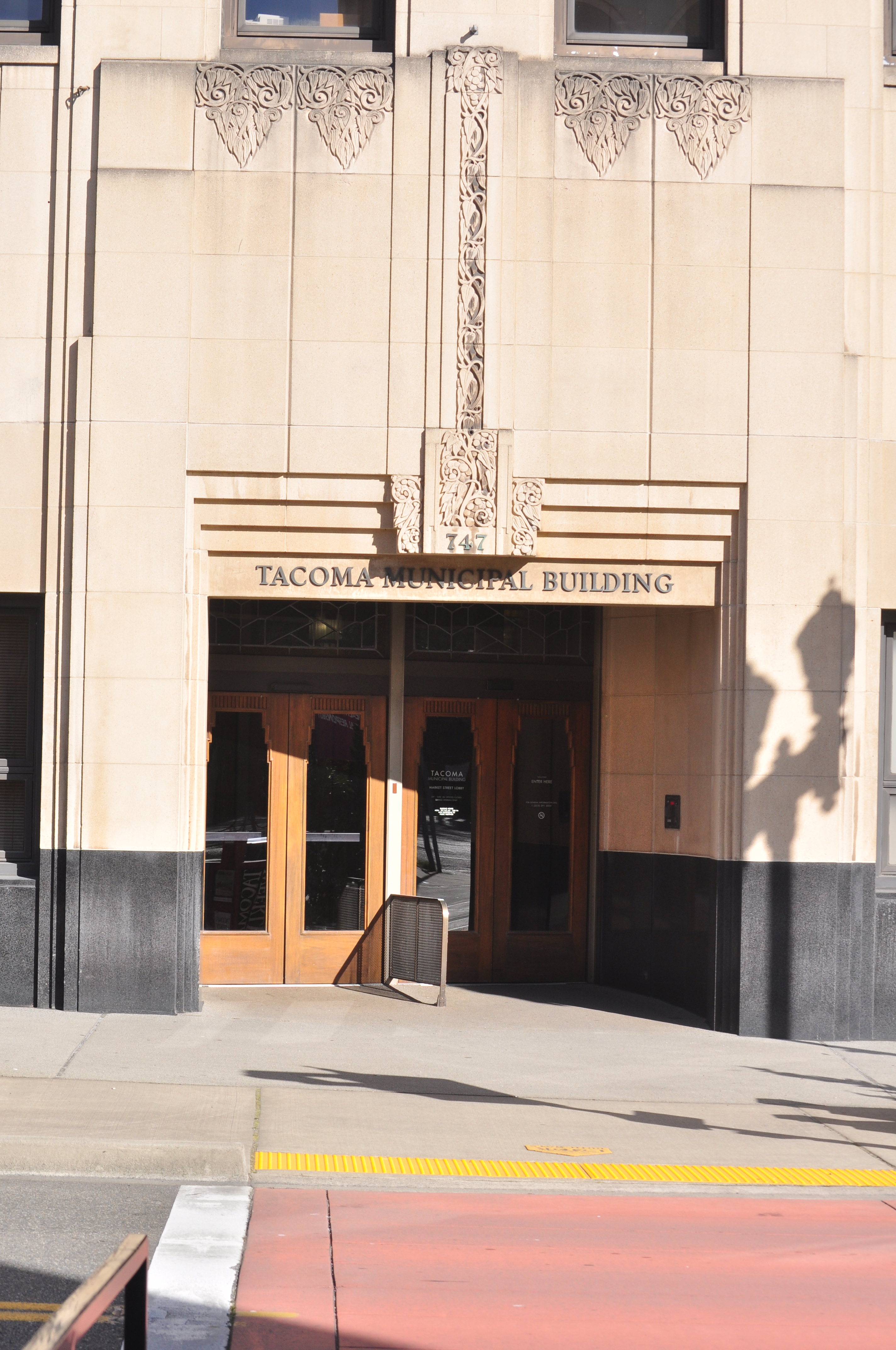 Art Deco building entrance with carved stonework and a sign reading Tacoma Municipal Building.