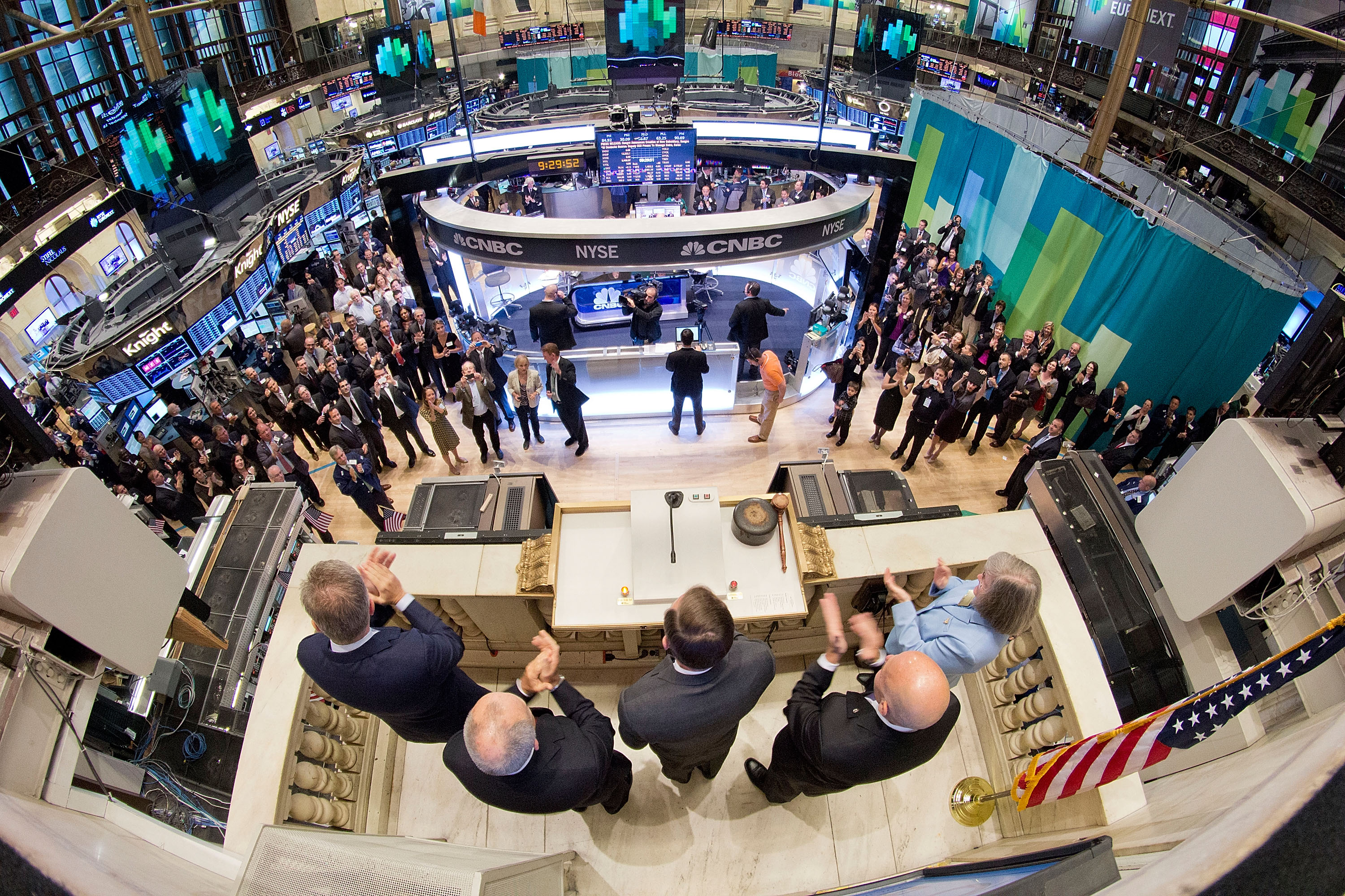 Aerial wide-angle view of a crowded stock exchange trading floor during a bell ceremony.