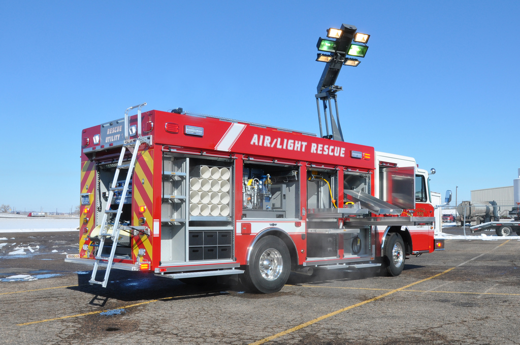 Red fire department Air/Light Rescue truck with elevated light tower deployed.
