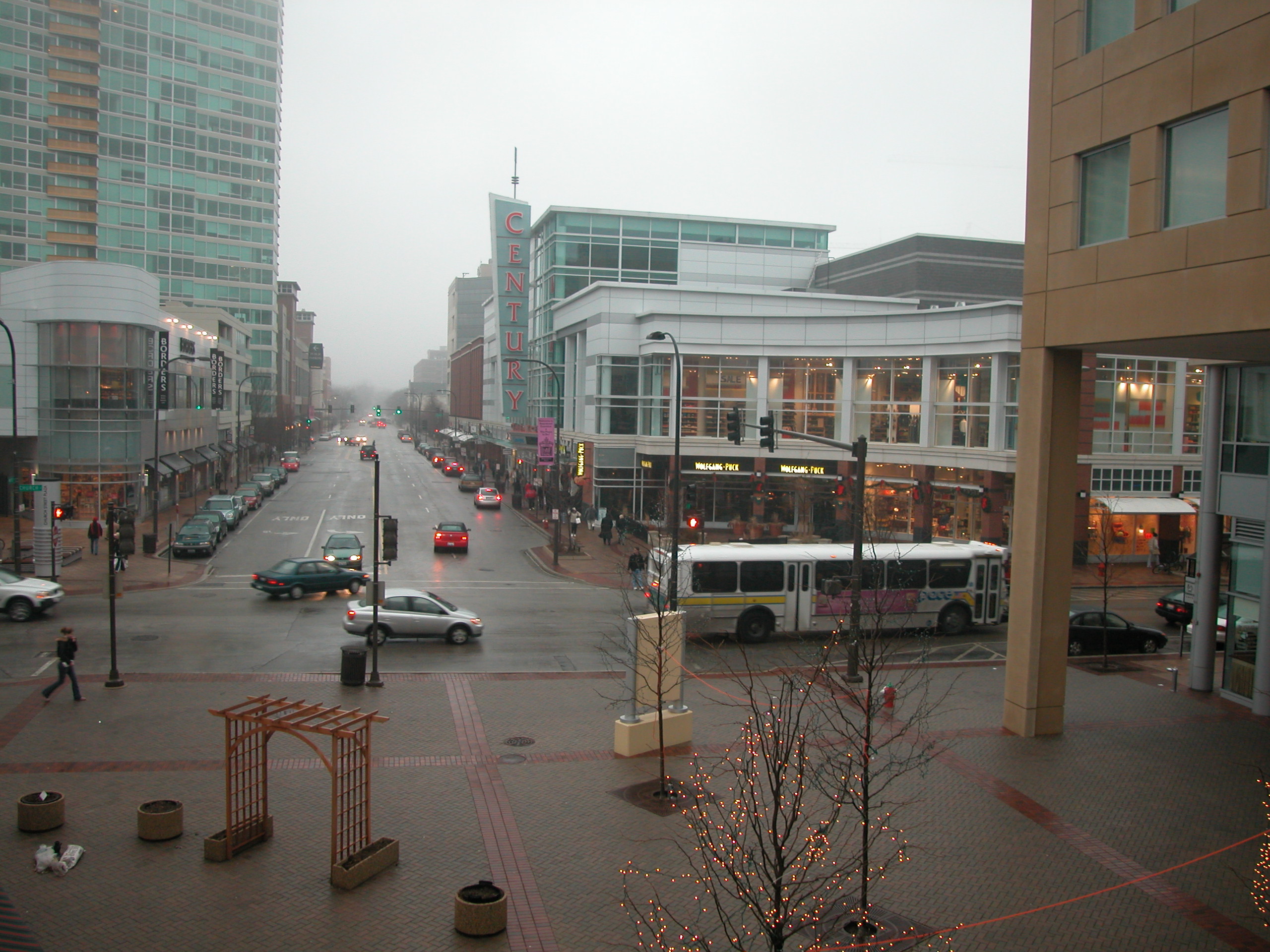 Downtown Evanston street corner with a bus, brick buildings, and bare trees.