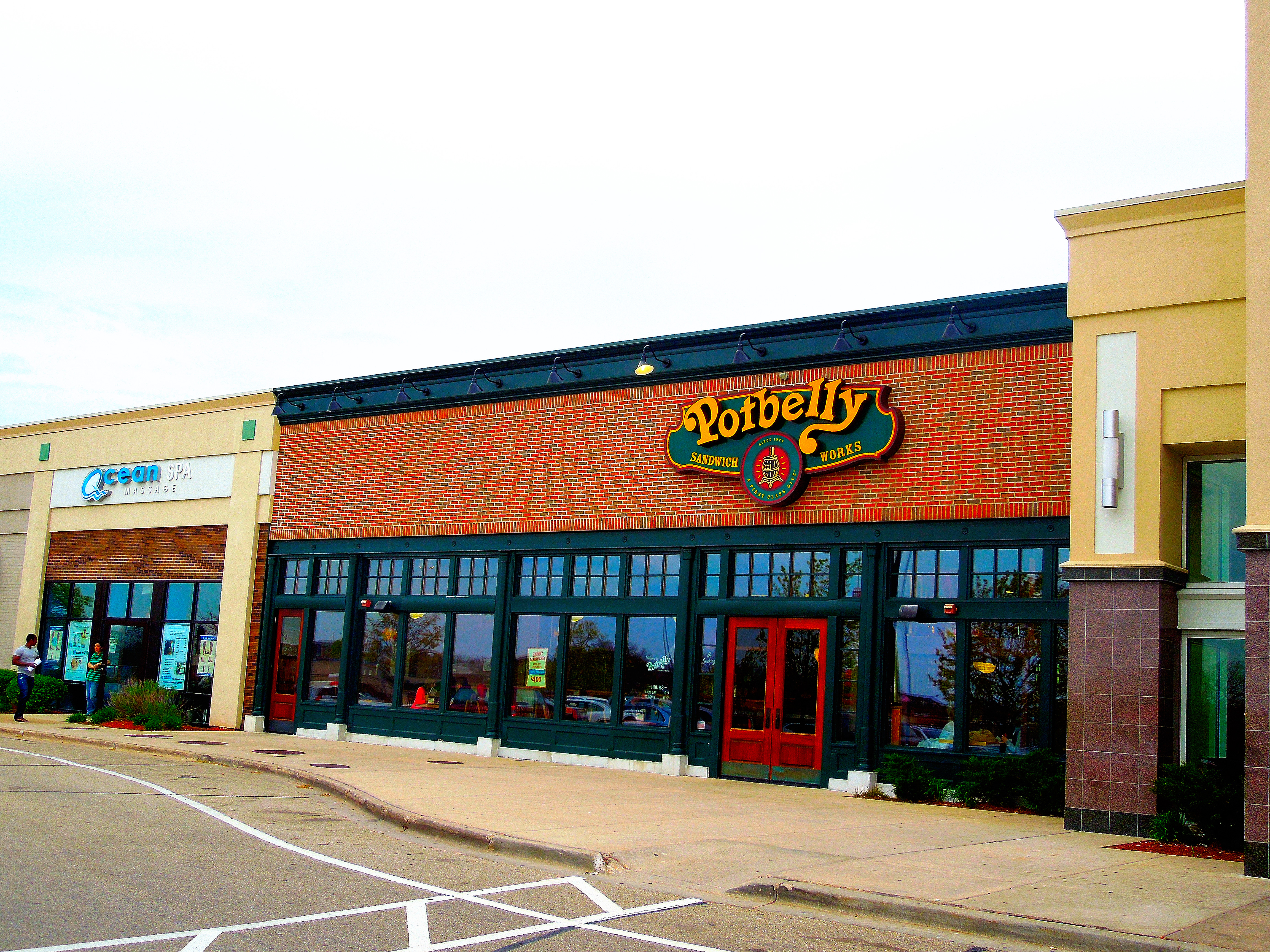 Potbelly Sandwich Works storefront in a brick strip mall with green trim and red doors