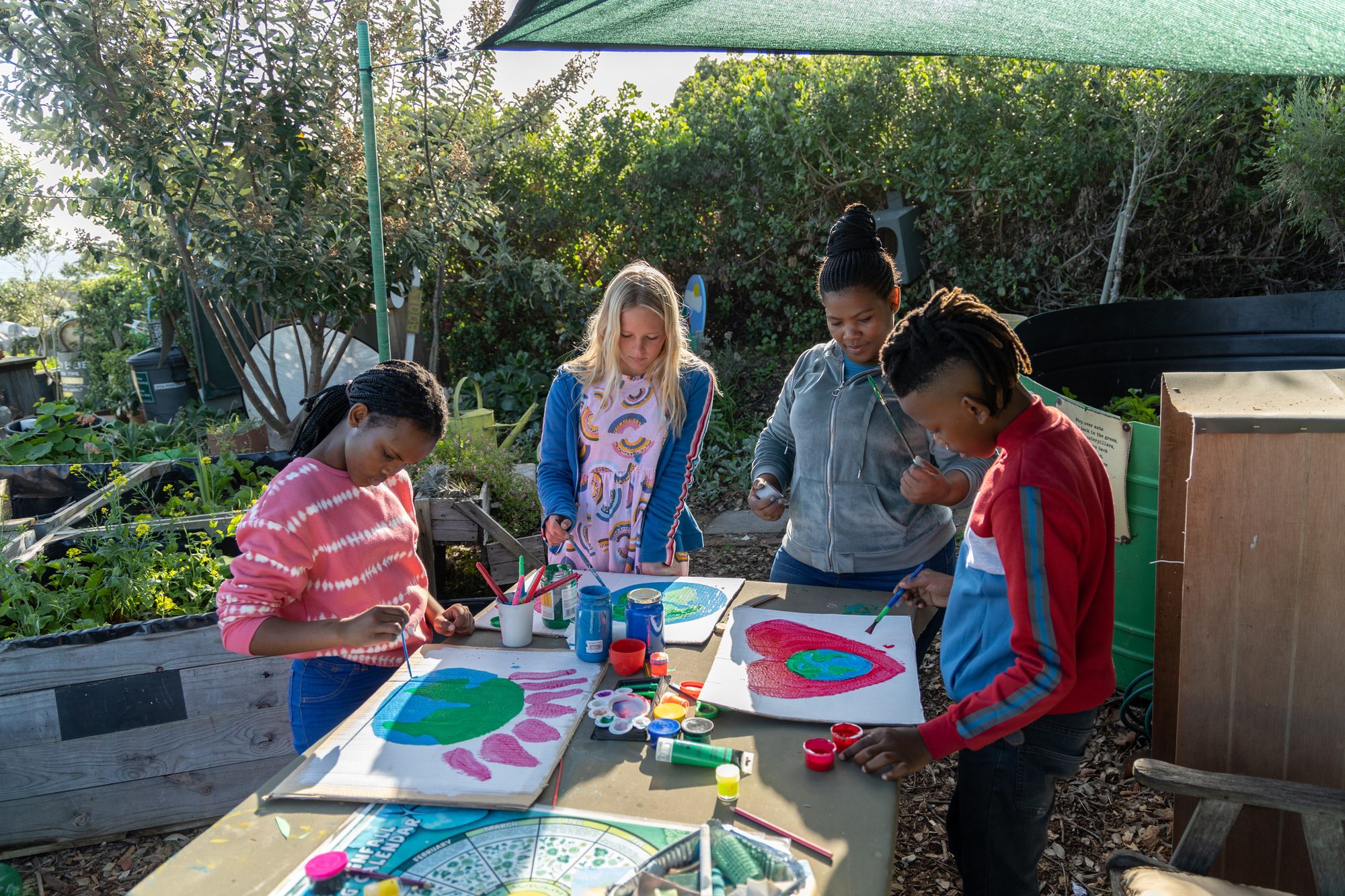 Group of school children making environmental art with their teacher