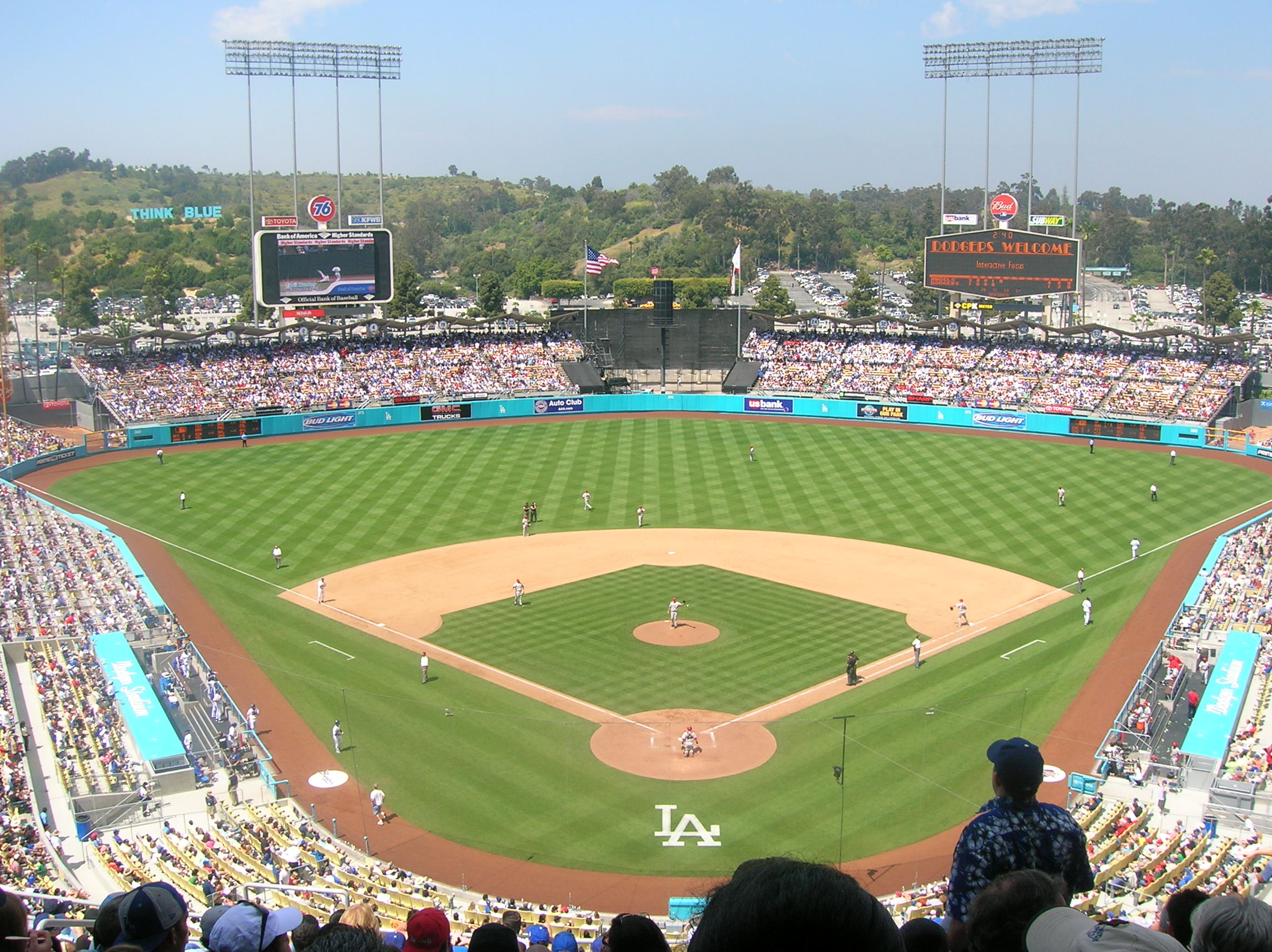 Aerial view of a packed Dodger Stadium during a baseball game with the LA logo on the field.
