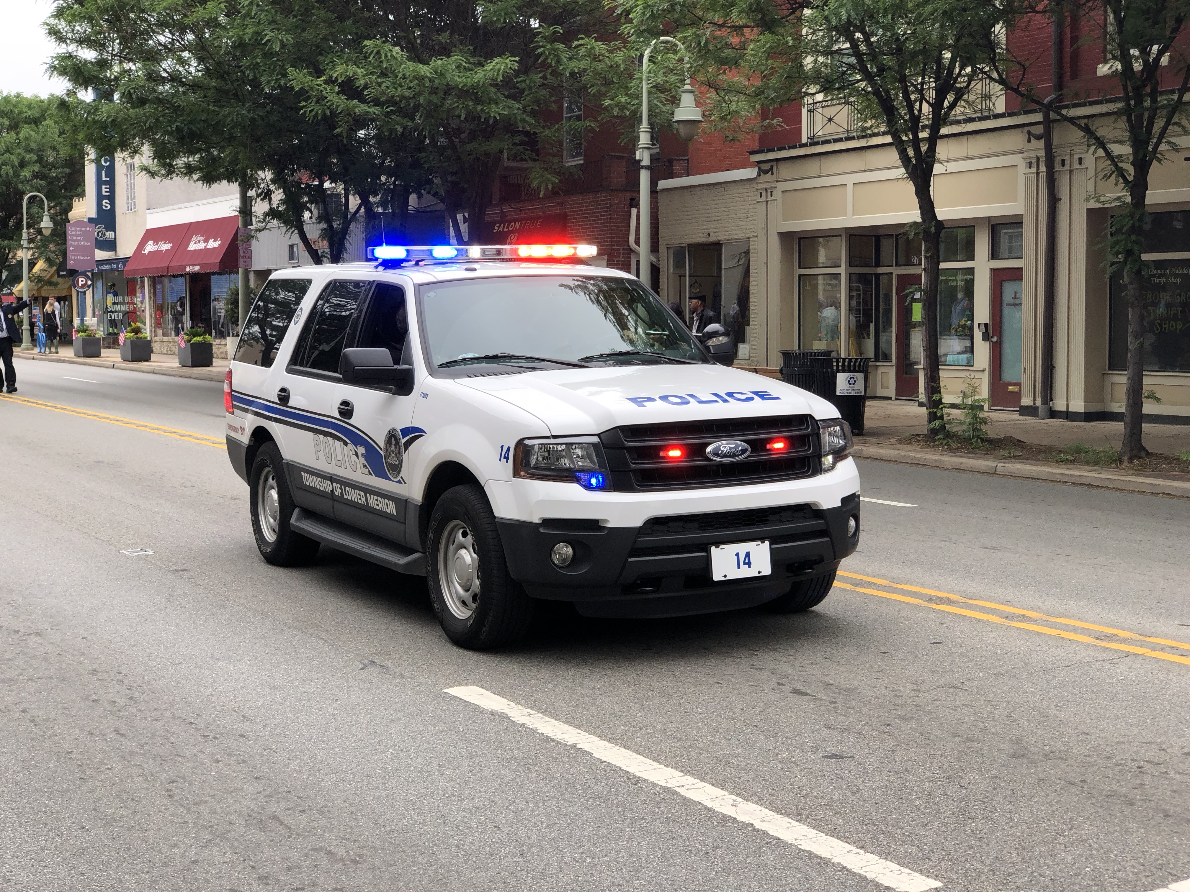 White Haverford Township Police SUV with emergency lights activated on a street.