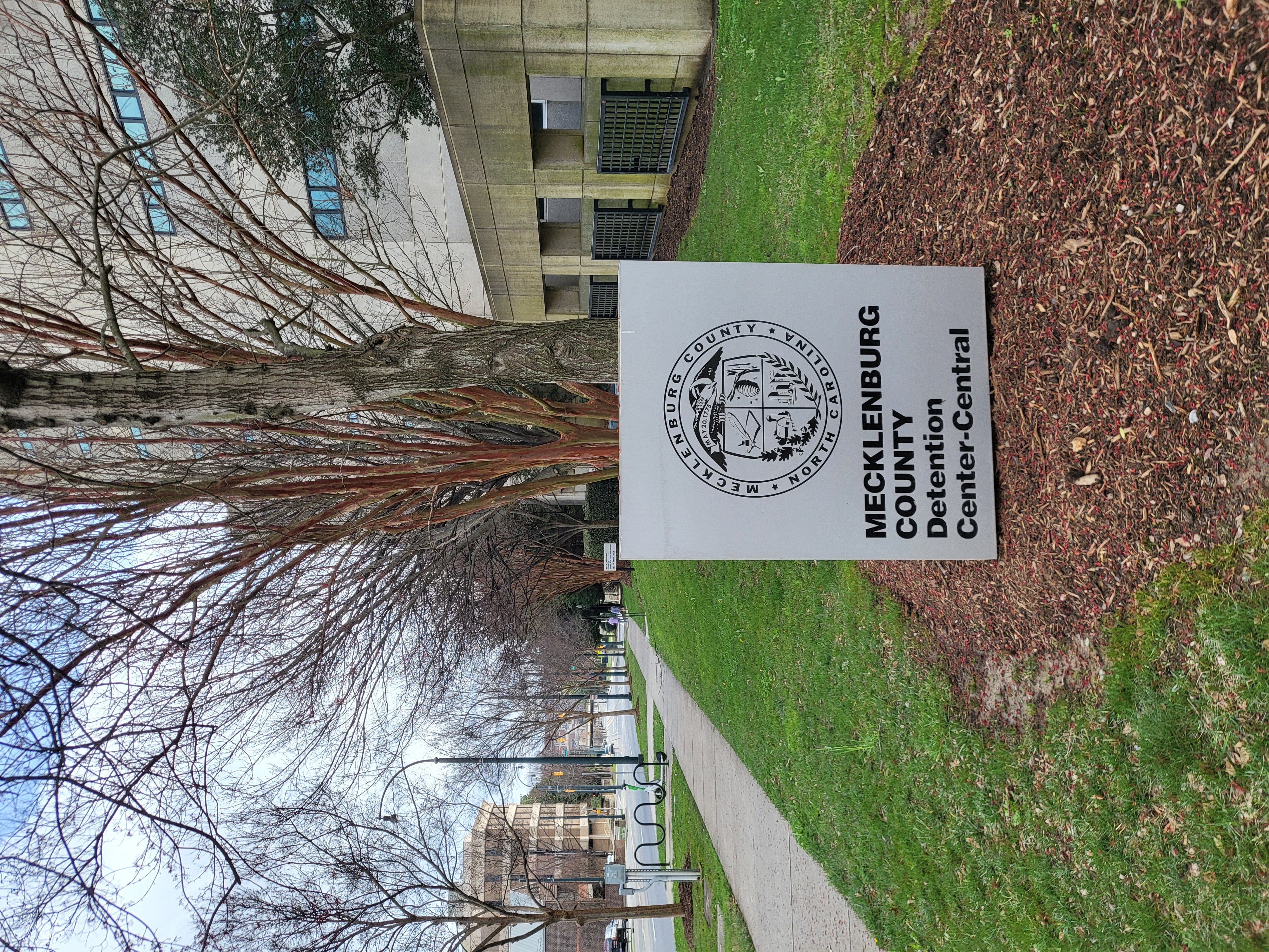 Sign for Mecklenburg County Detention Center-Central in front of a large concrete building.