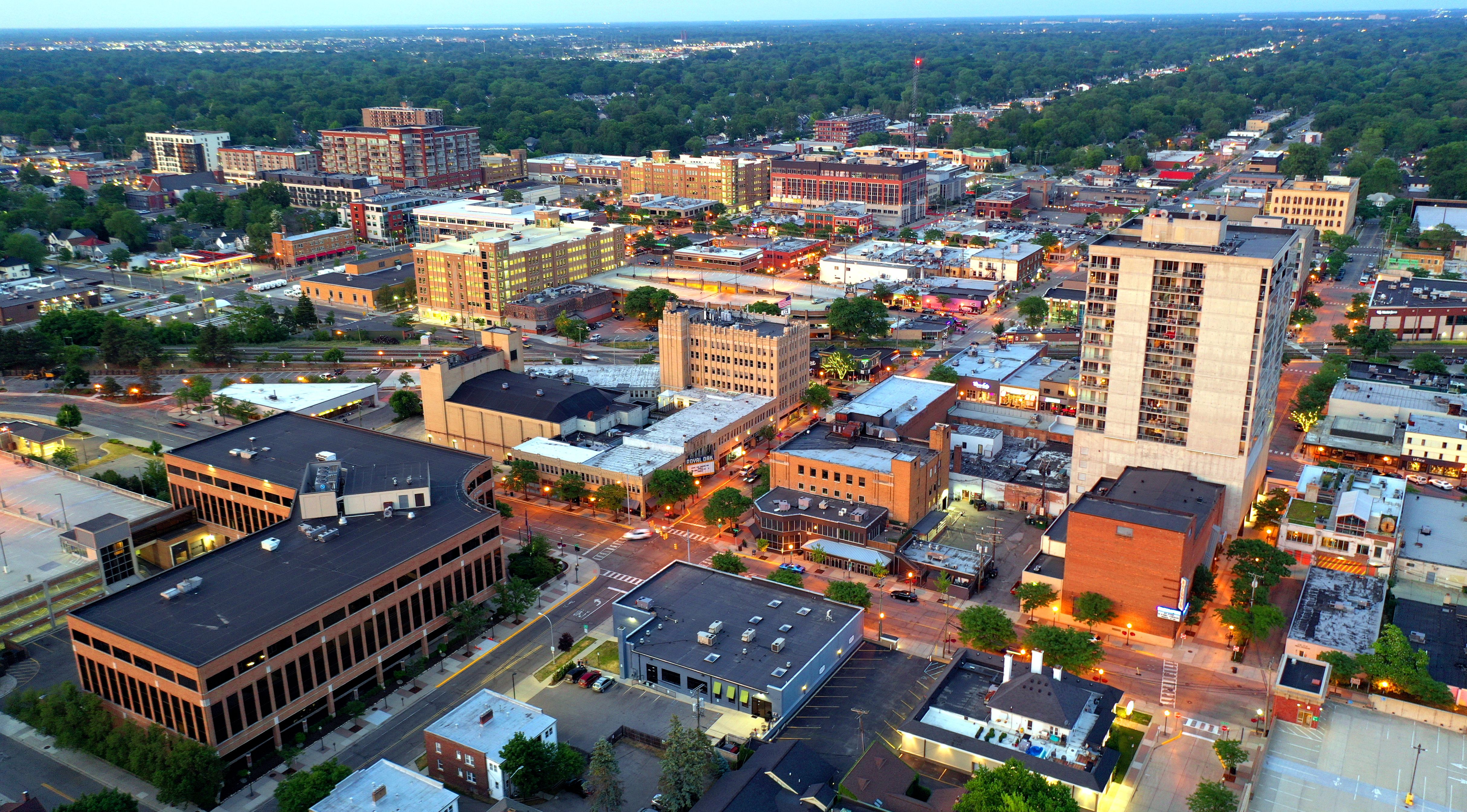 Aerial dusk view of downtown Royal Oak, Michigan, with streets and commercial buildings.
