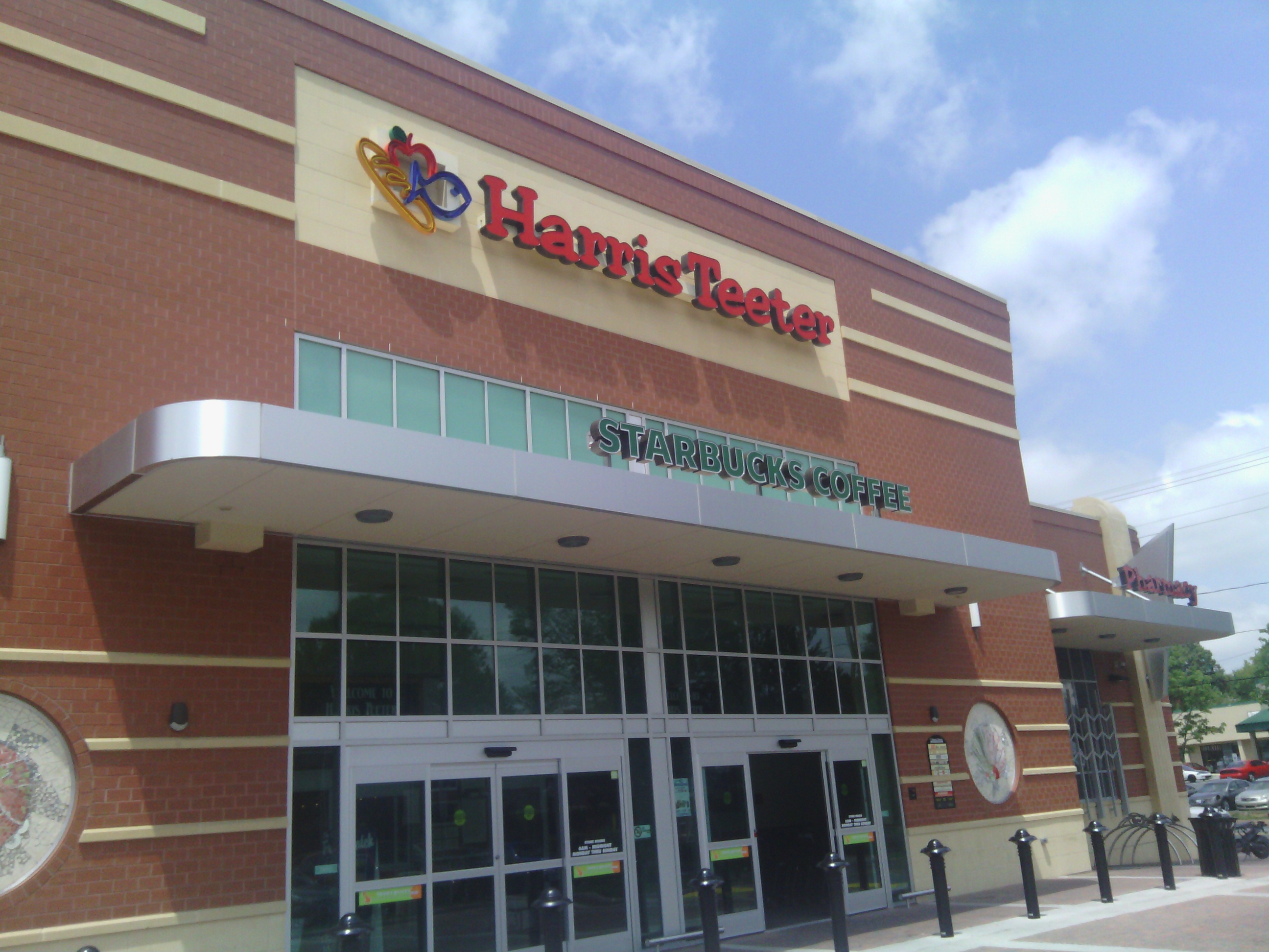 Exterior of a Harris Teeter grocery store with brick facade and red signage.
