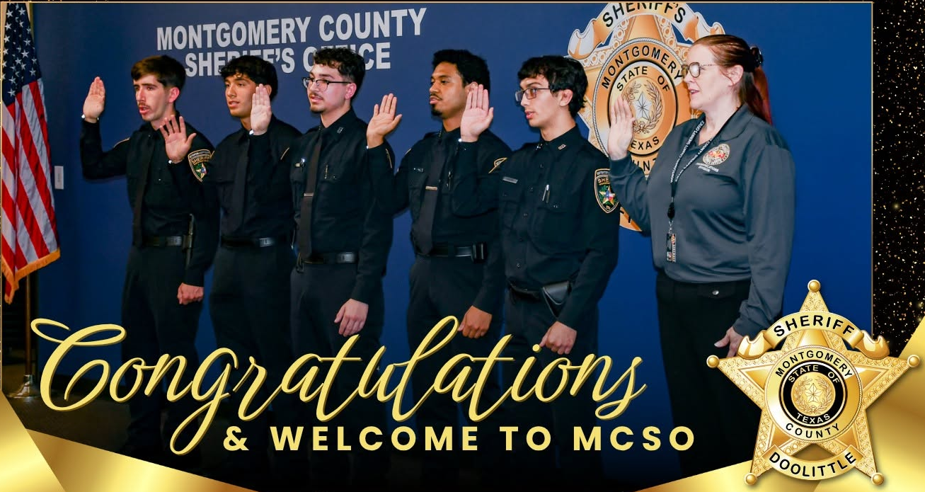 Six uniformed people raise their right hands during a swearing-in ceremony before a sheriff's office backdrop.