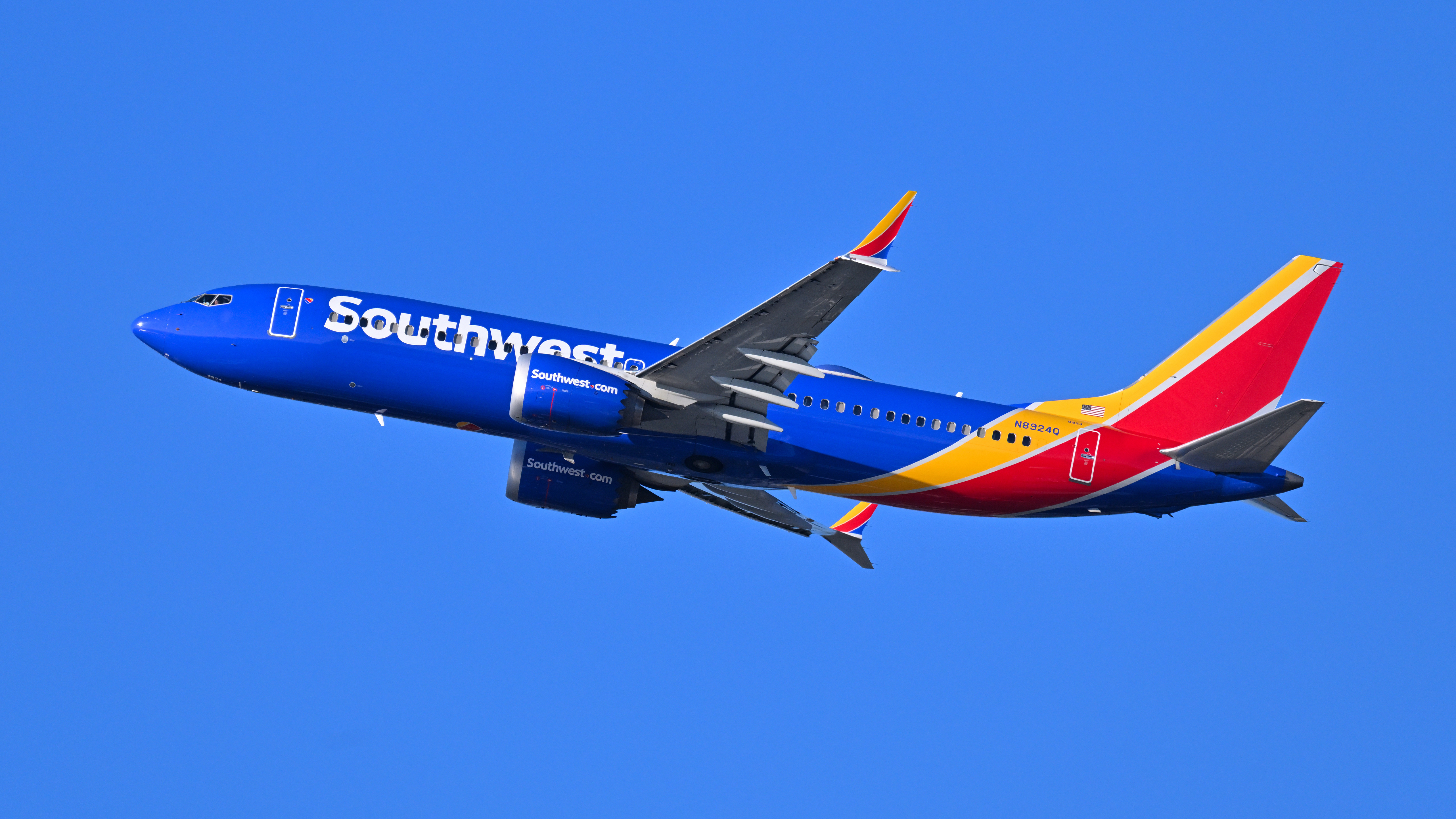 Southwest Airlines jet in blue and red livery climbing after takeoff.