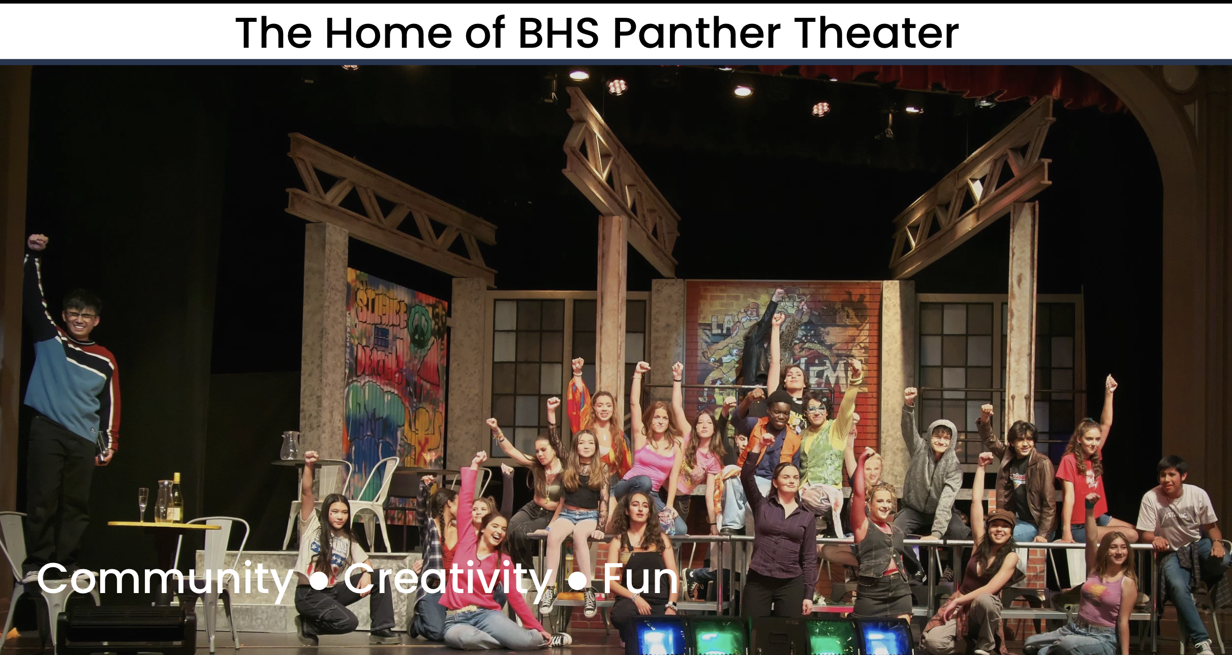 Burlingame High School Panther Theater cast members pose on stage with fists raised in front of a graffiti-covered set backdrop.