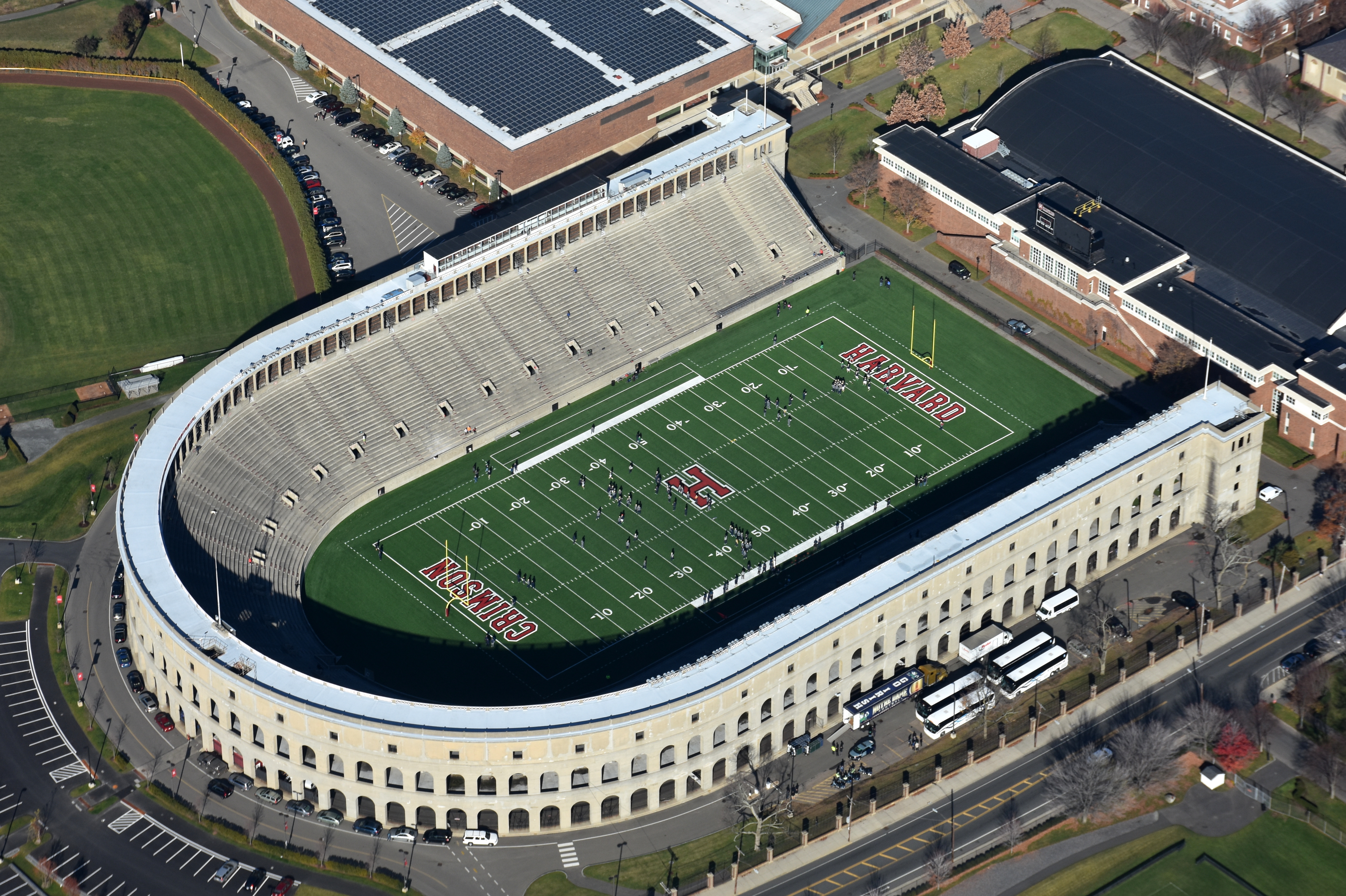 Aerial view of an oval concrete football stadium with a green turf field.