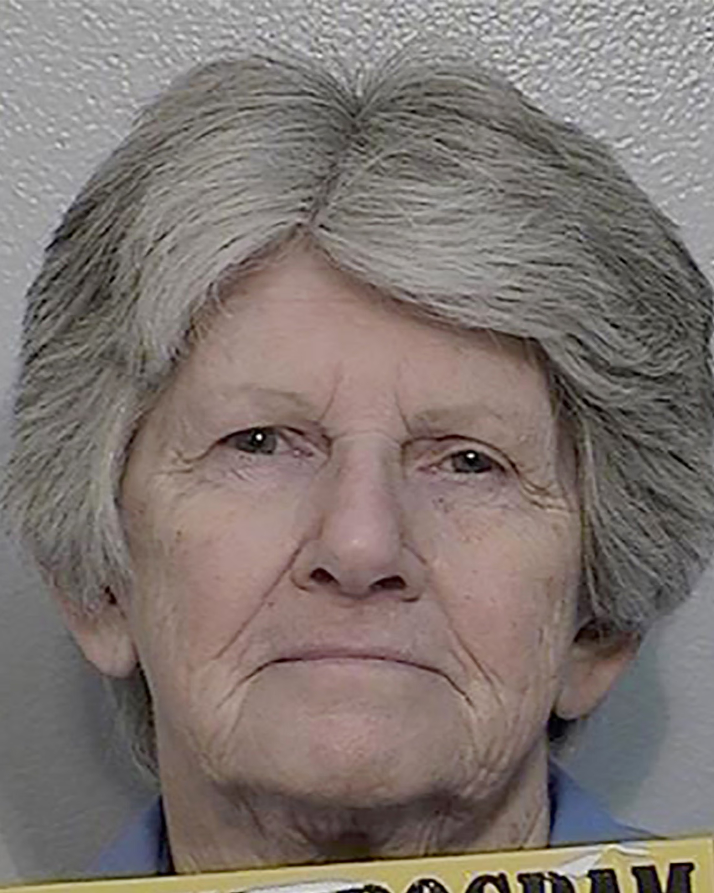 Elderly woman with short gray hair in a 2020 institutional photograph against a plain wall