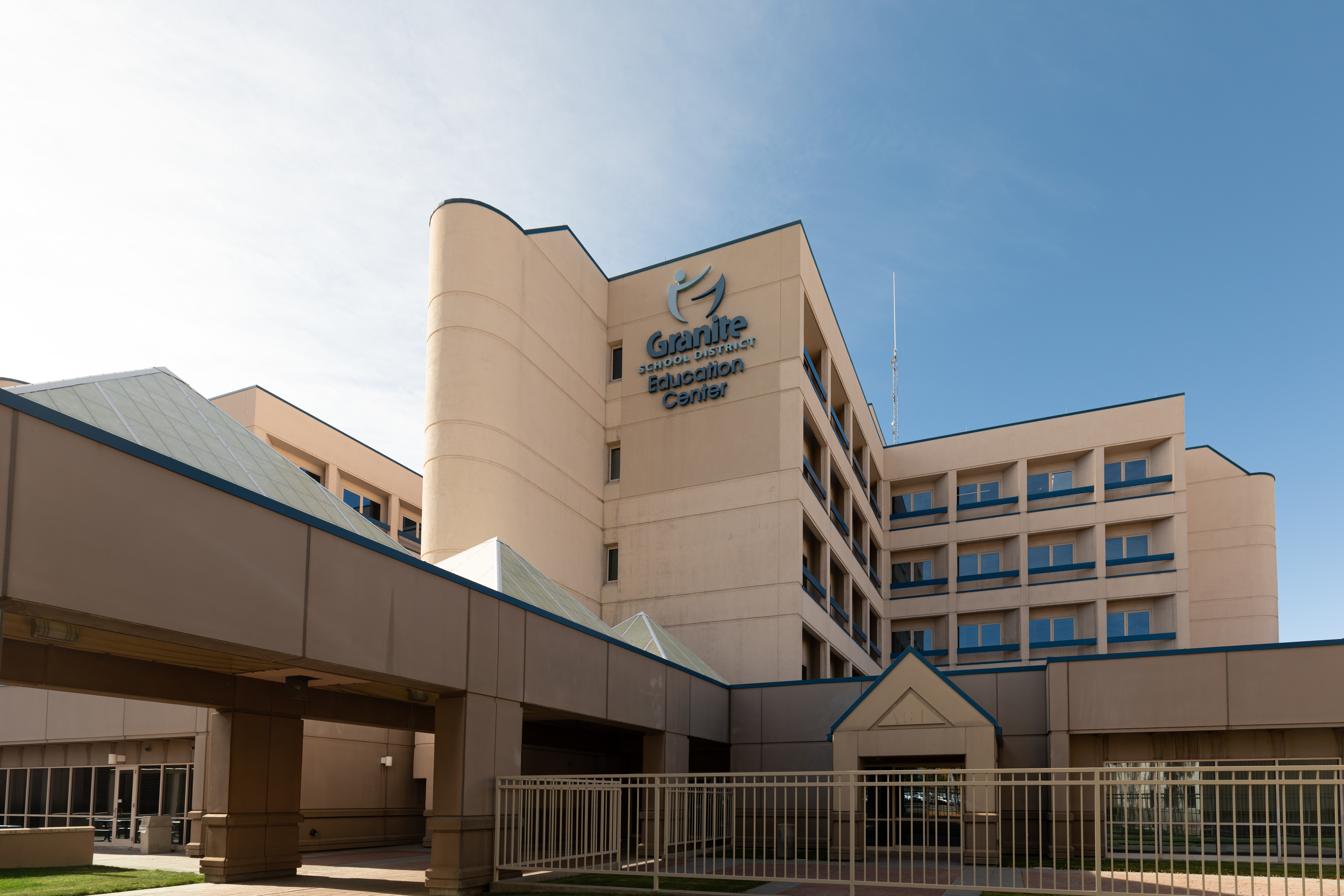 Multi-story beige building with blue trim and a sign reading Granite Education Center.