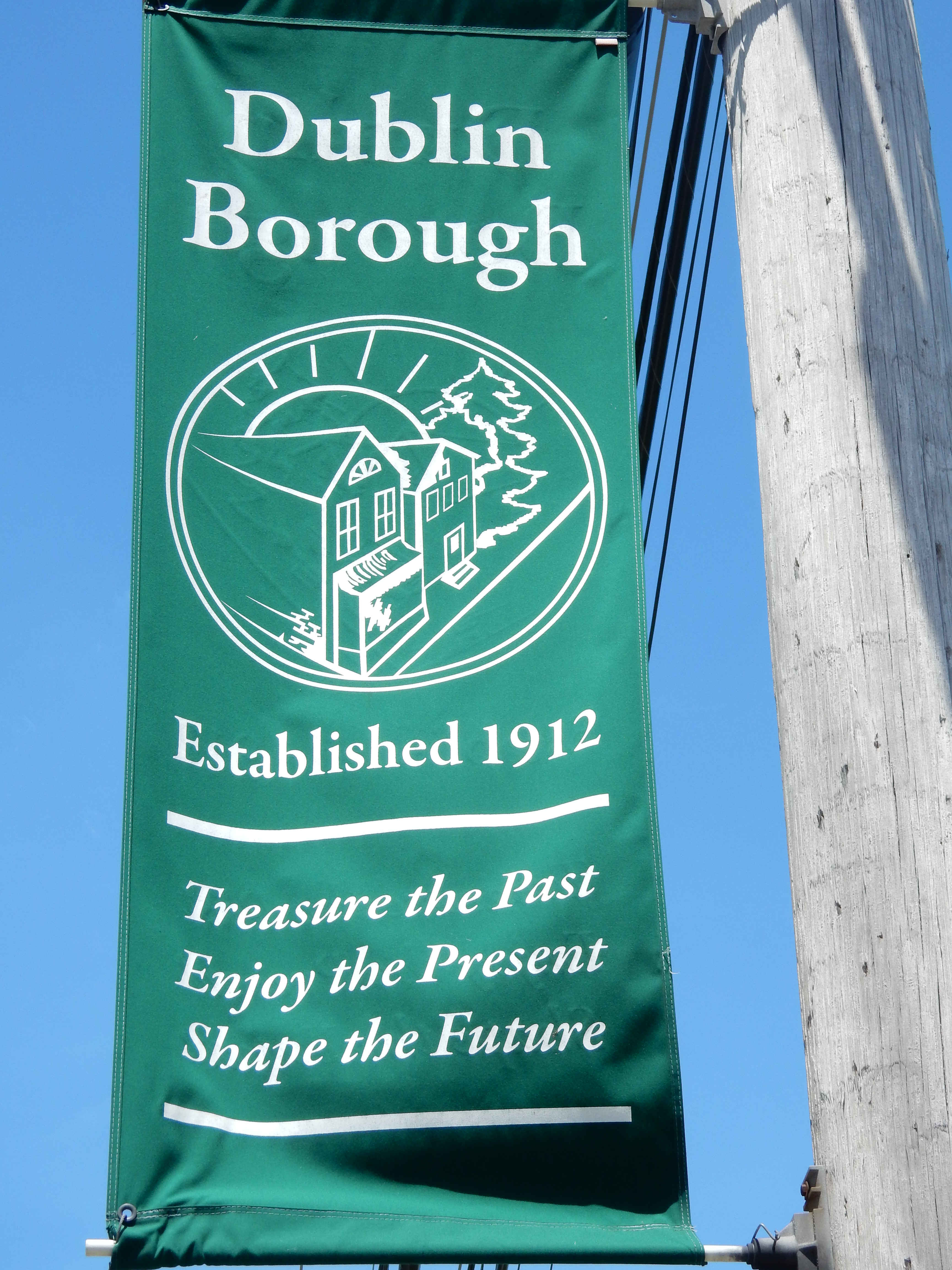 Green borough banner on a pole reading 'Dublin Borough, Established 1912' against blue sky.