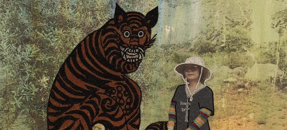 Mixed-media painting detail showing a beaded tiger and a figure in a wide-brimmed hat against a layered landscape.