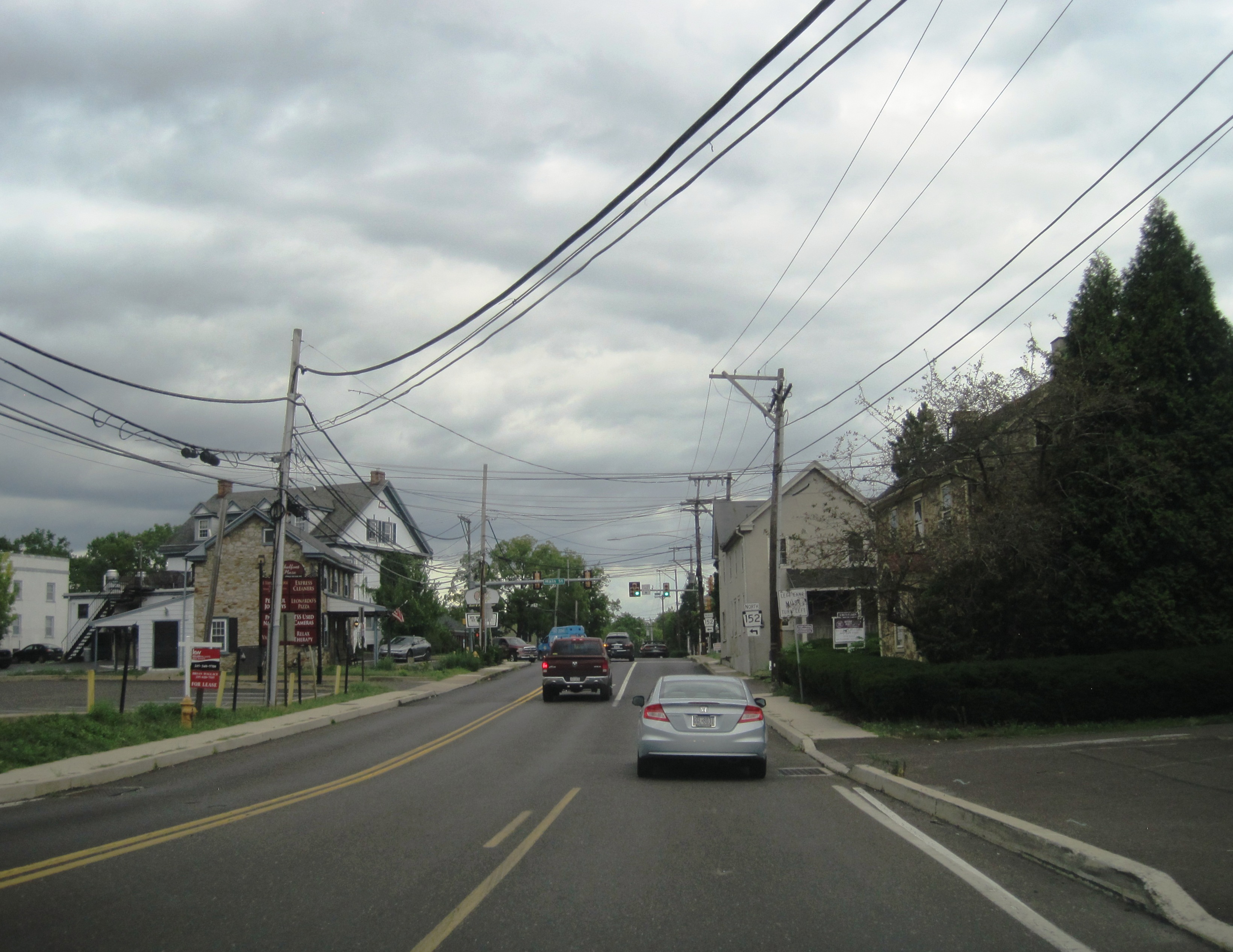 Two-lane road lined with utility poles and buildings in a small Pennsylvania town.