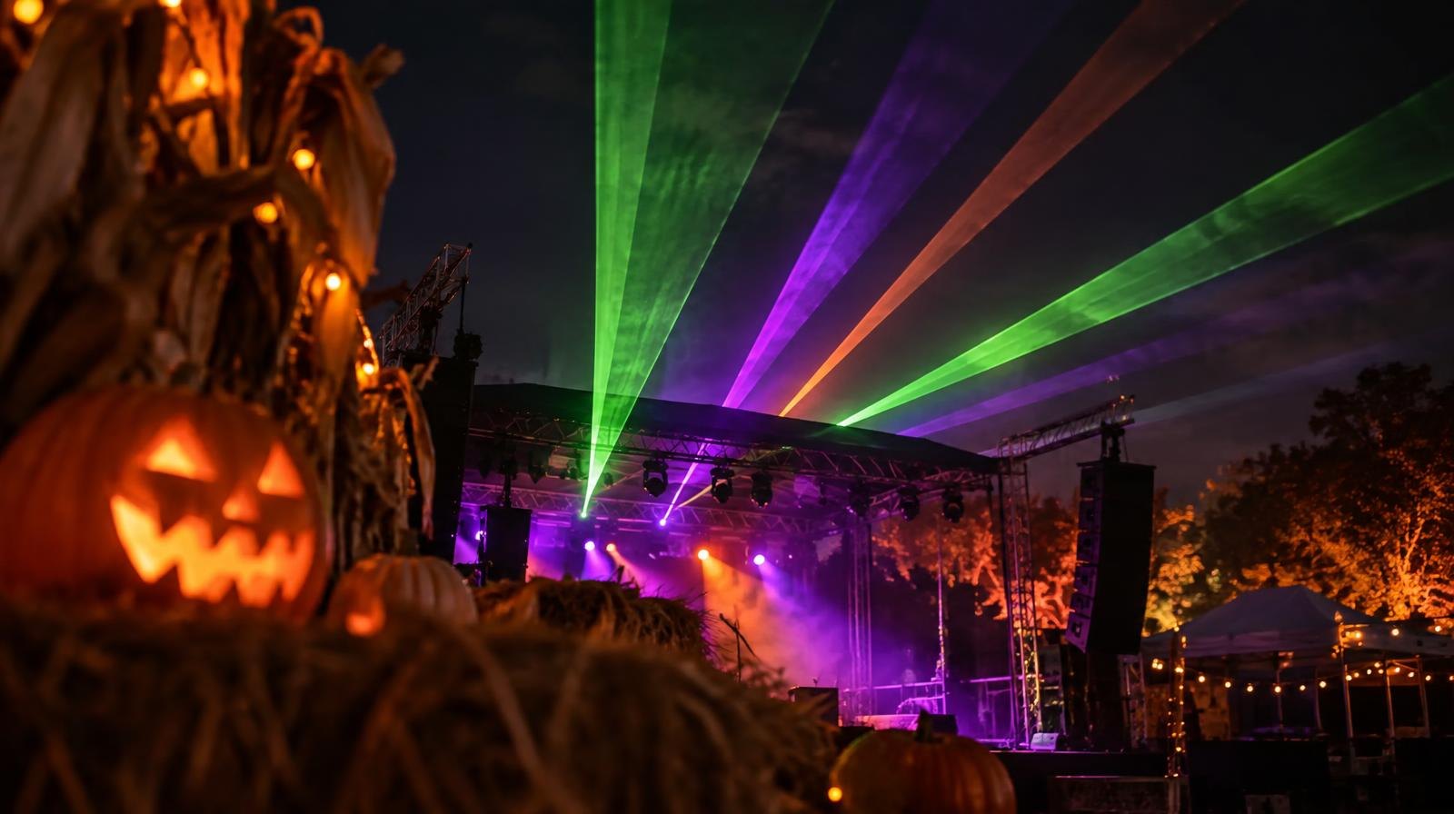 Colorful laser light beams in green, purple, and orange against a dark night sky.