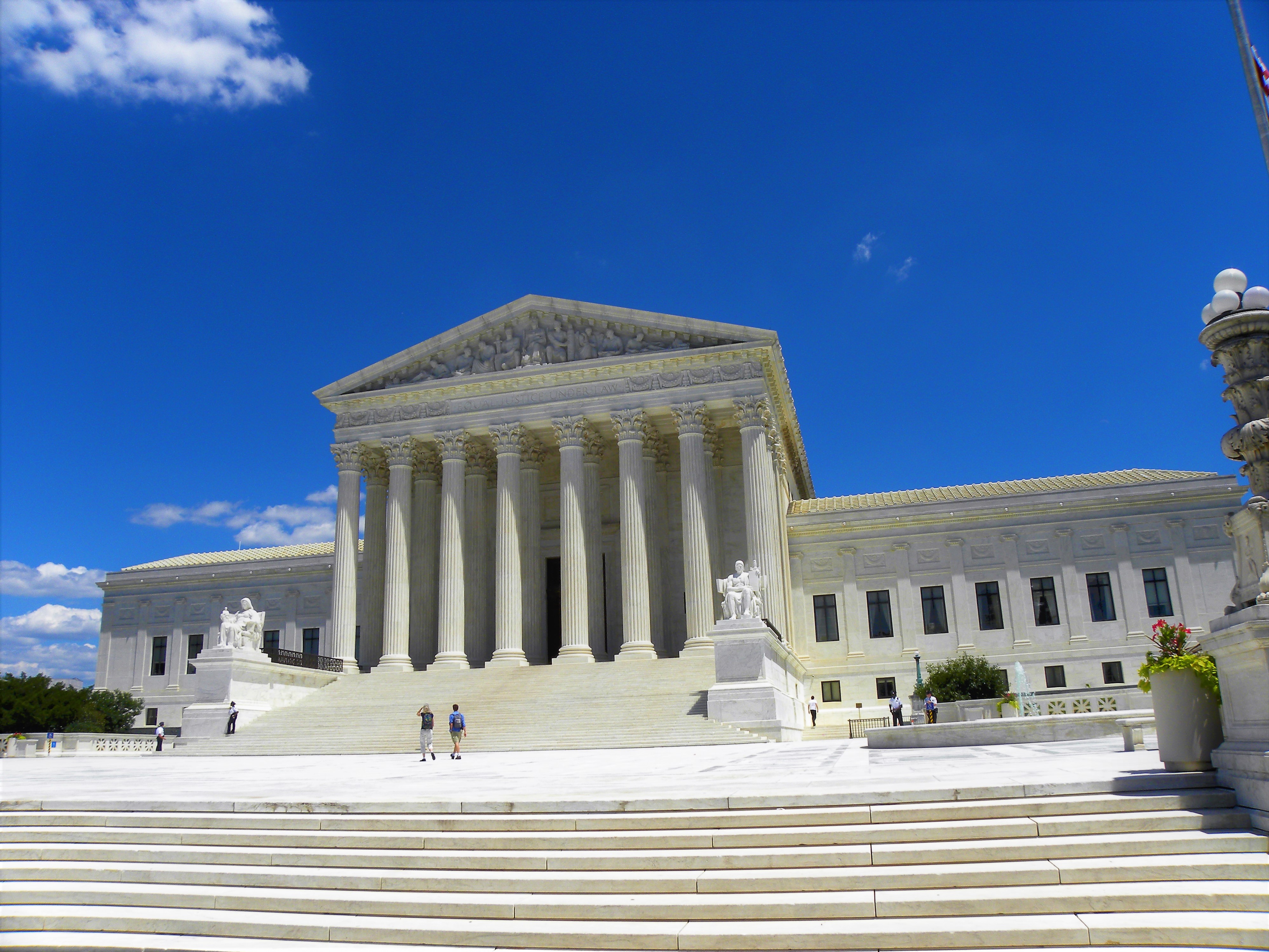 White marble Supreme Court building with tall columns and wide front steps.