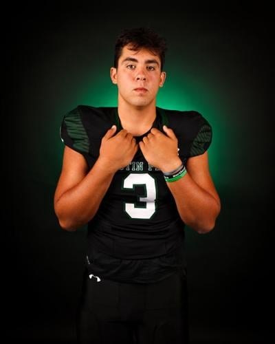 Young male athlete in black number 3 football jersey posed against a dark background.